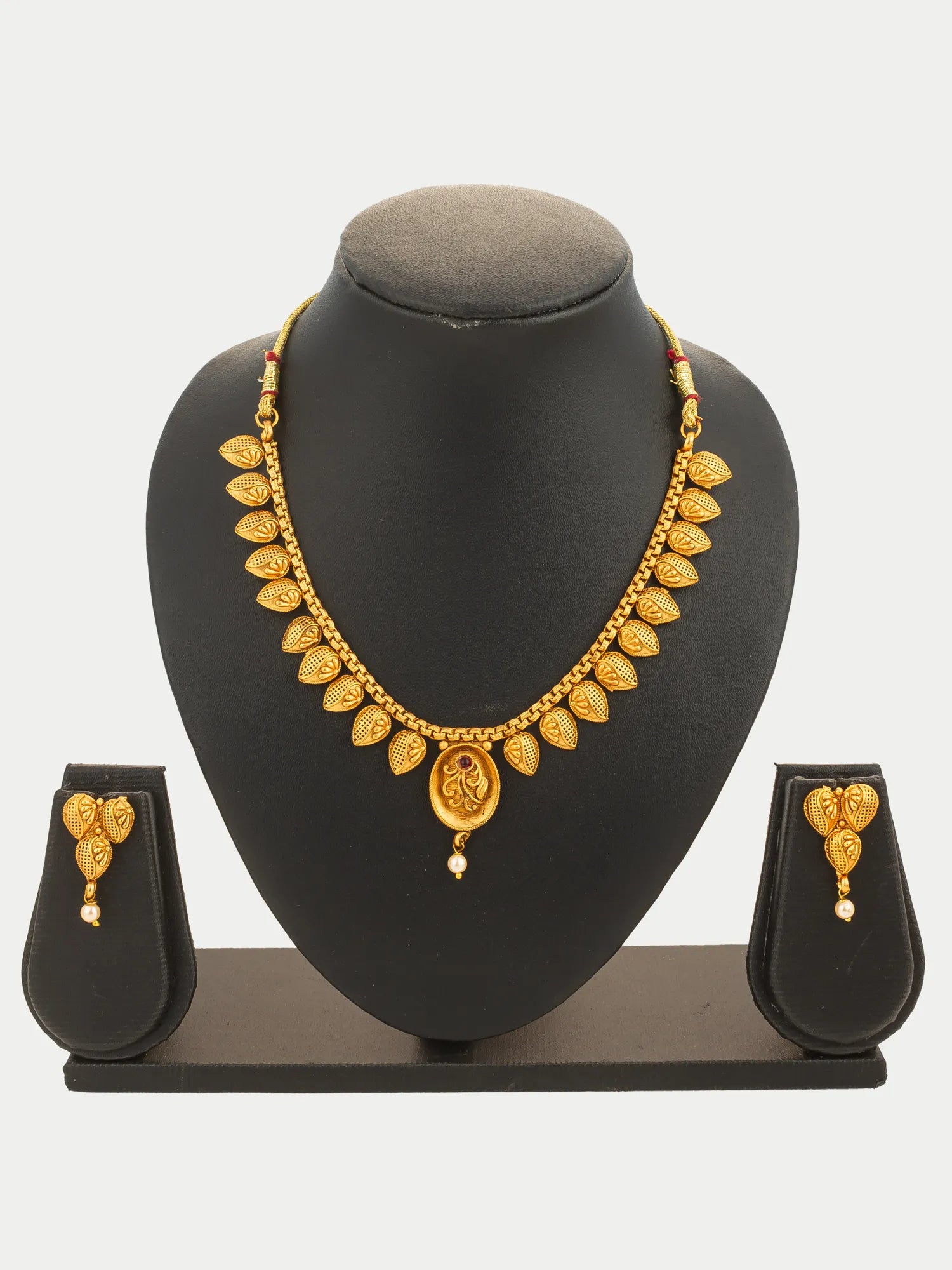 Gold necklace and earrings set on a black mannequin bust with a white background