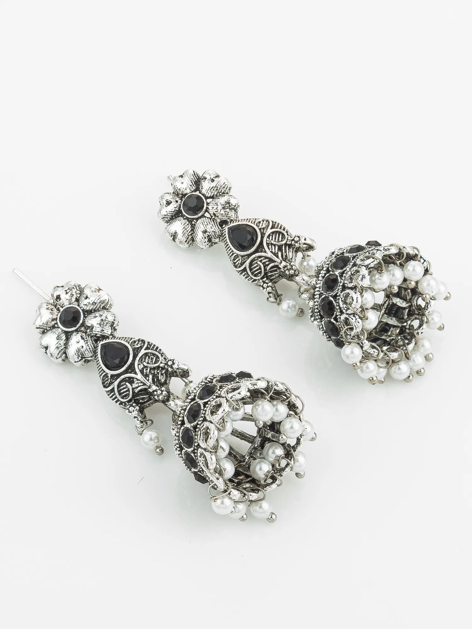 Pair of ornate silver earrings with black and pearl accents on a white background