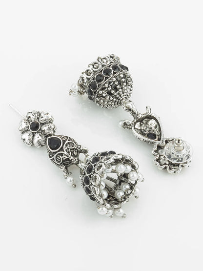 Pair of ornate silver earrings with black and clear gemstones on a white background