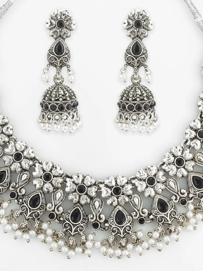 Ornate silver necklace with black and white stones and matching earrings on a white background