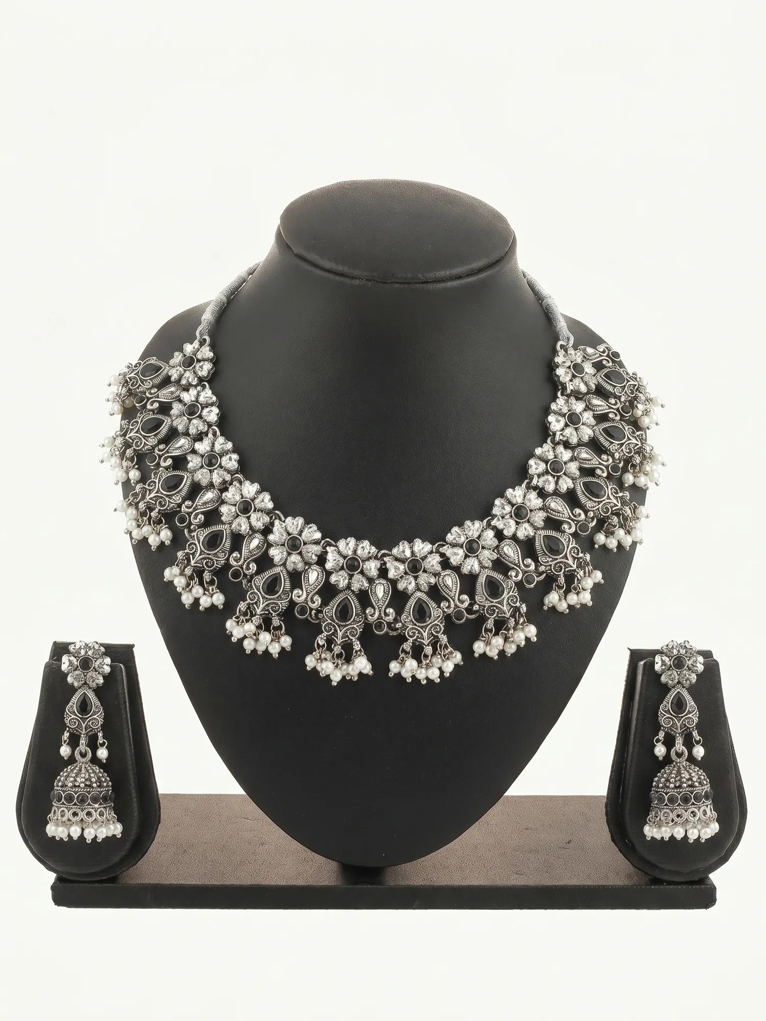 Silver necklace and earrings set on a black mannequin bust with a white background