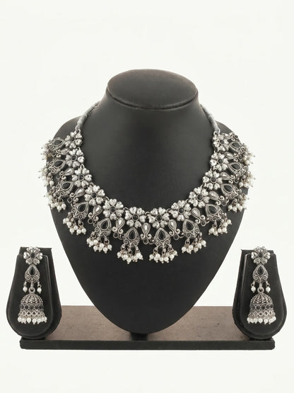 Silver necklace and earrings set on a black mannequin bust with a white background