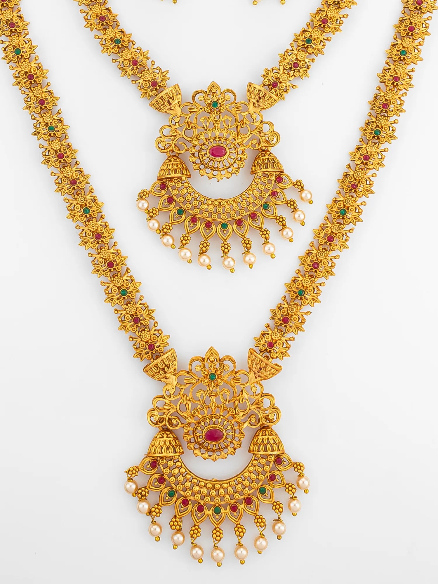 Gold necklace with red and green gemstones on a white background