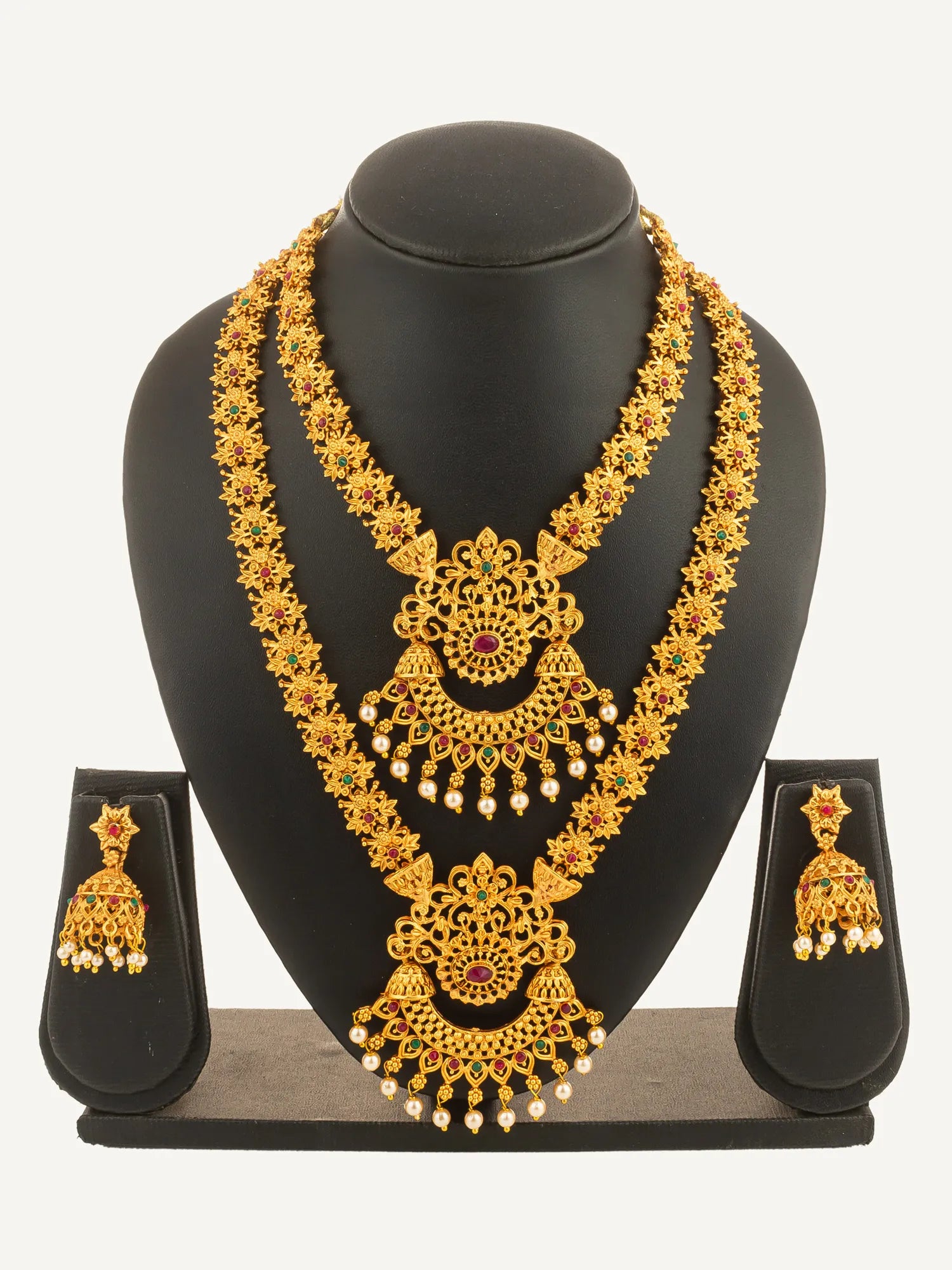 Gold necklace and earrings set on a black mannequin bust with a white background