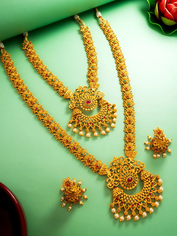 Gold necklace and earrings set on a green background