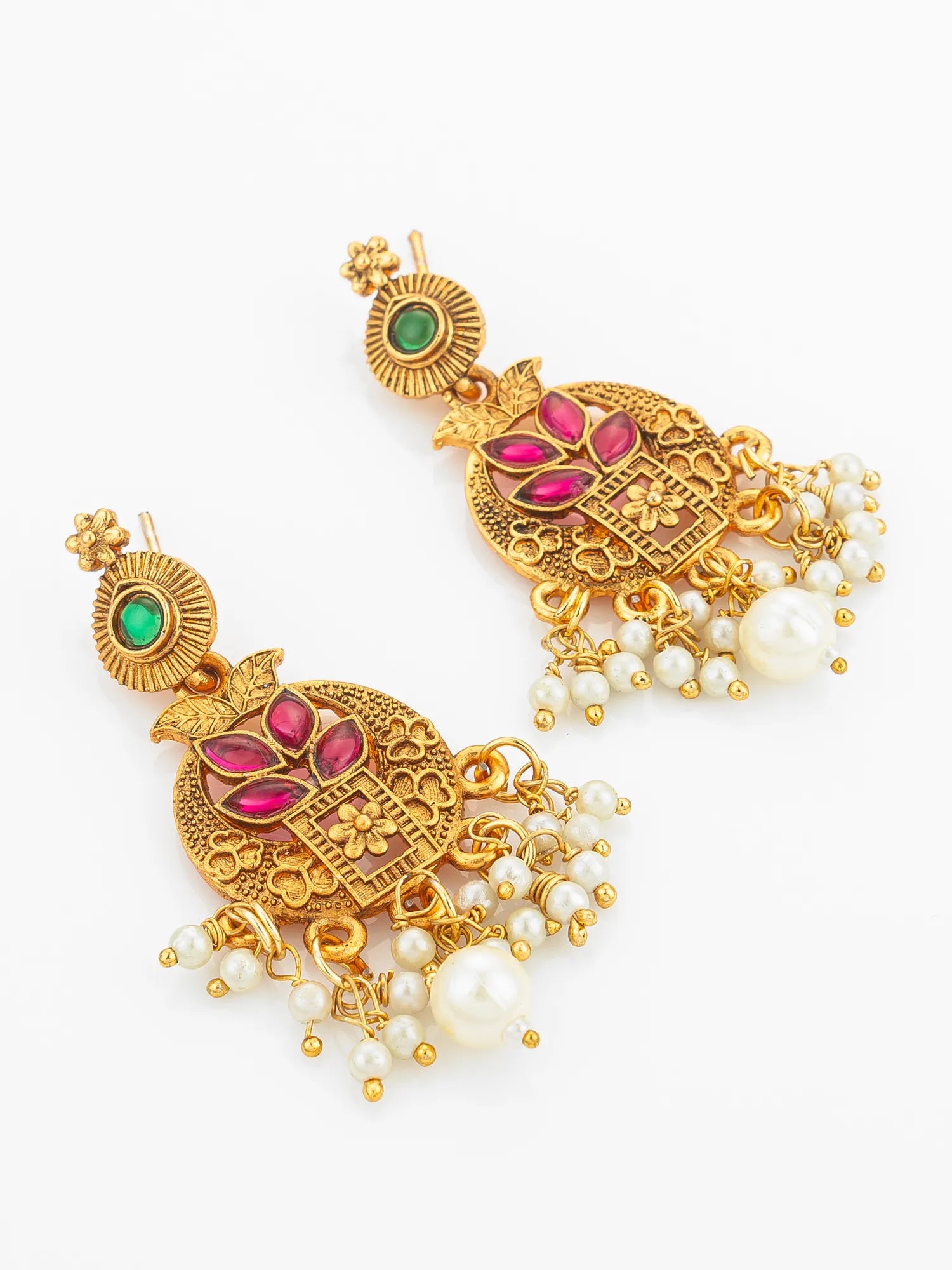 Pair of gold earrings with red stones and pearl drops on a white background