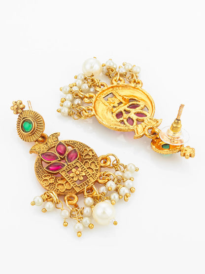 Pair of gold earrings with gemstones and pearls on a white background