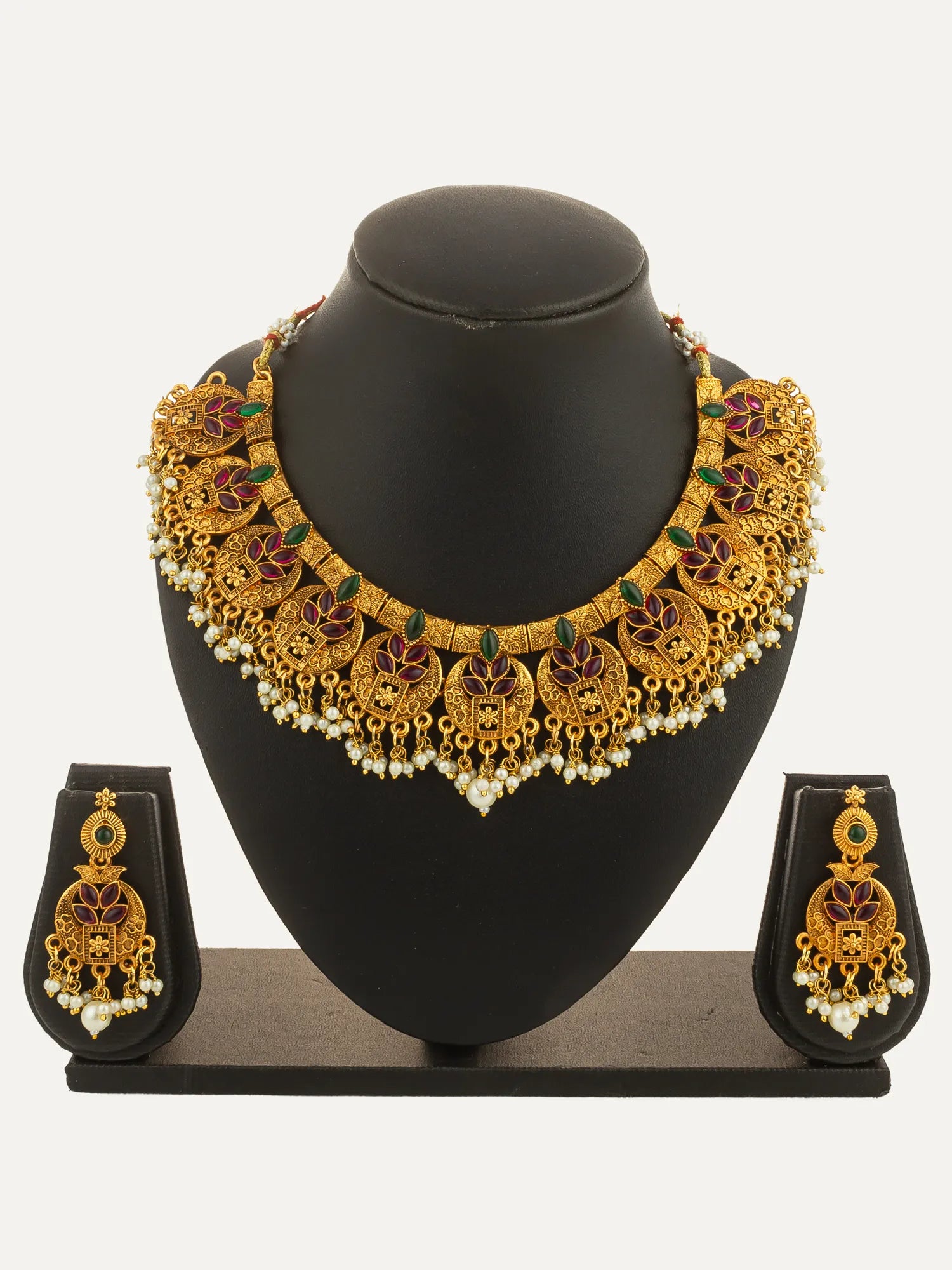 Gold necklace and earrings set on a black mannequin bust with a white background