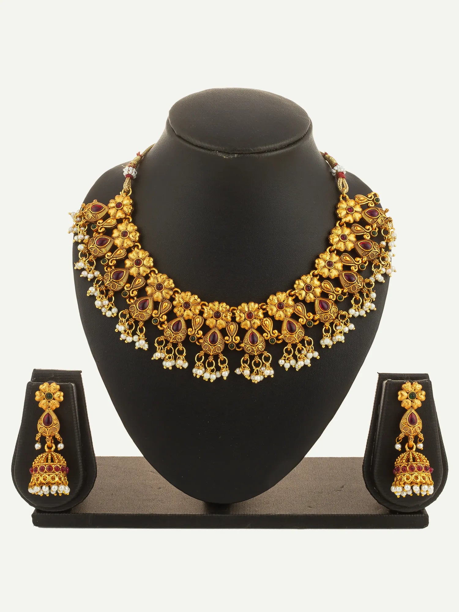 Gold necklace and earrings set on a black mannequin bust with a white background
