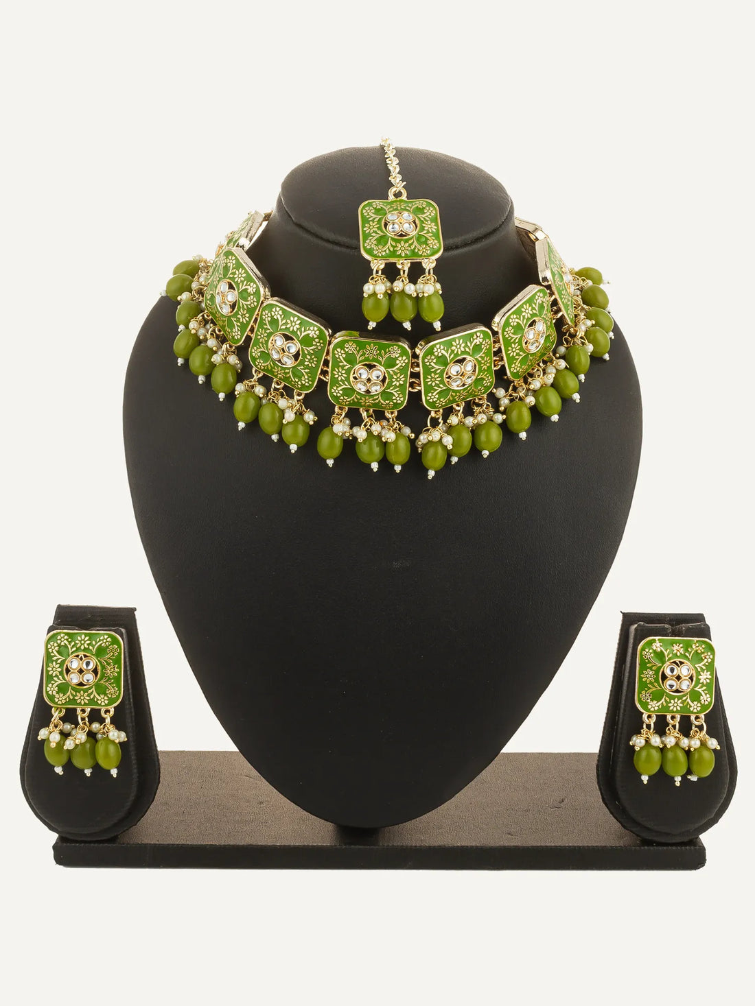 Green jewelry set with necklace, earrings, and bangles on a green background