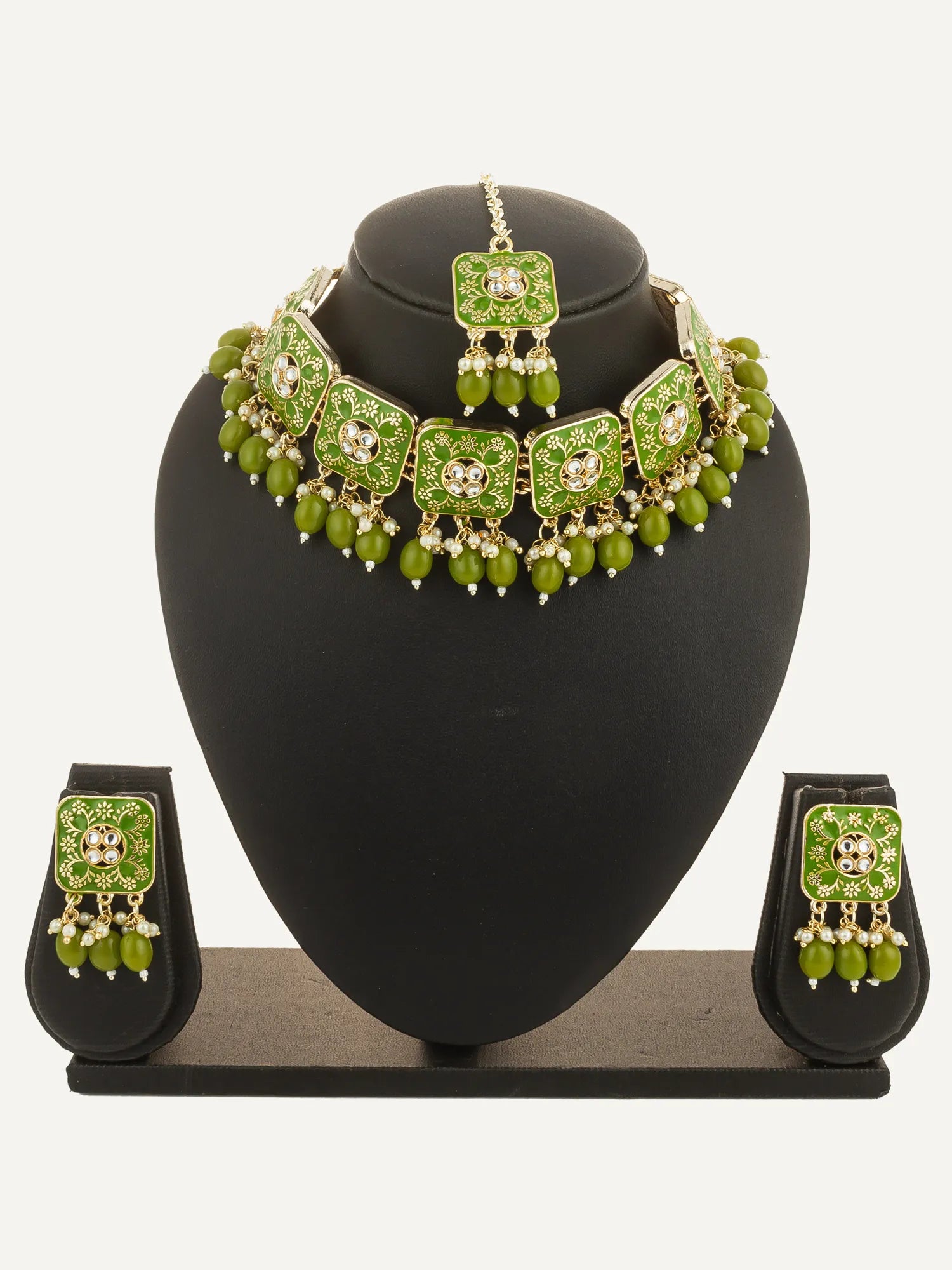 Green jewelry set with necklace, earrings, and ring on a black stand