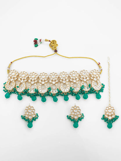 Gold and green jewelry set including necklace, earrings, and headpiece on a white background