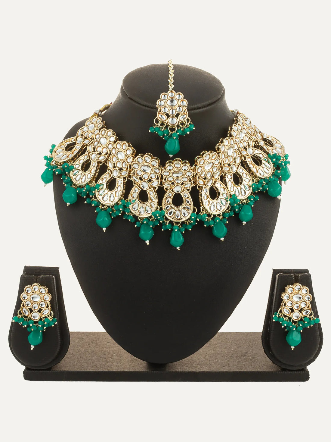 Gold and green jewelry set on a green background