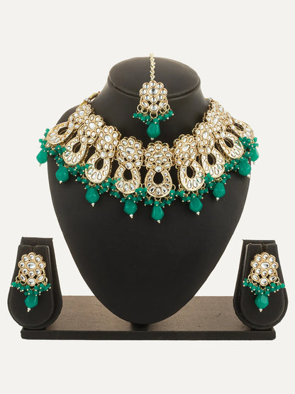 Jewelry set with necklace, earrings, and tikka on a black stand against a white background