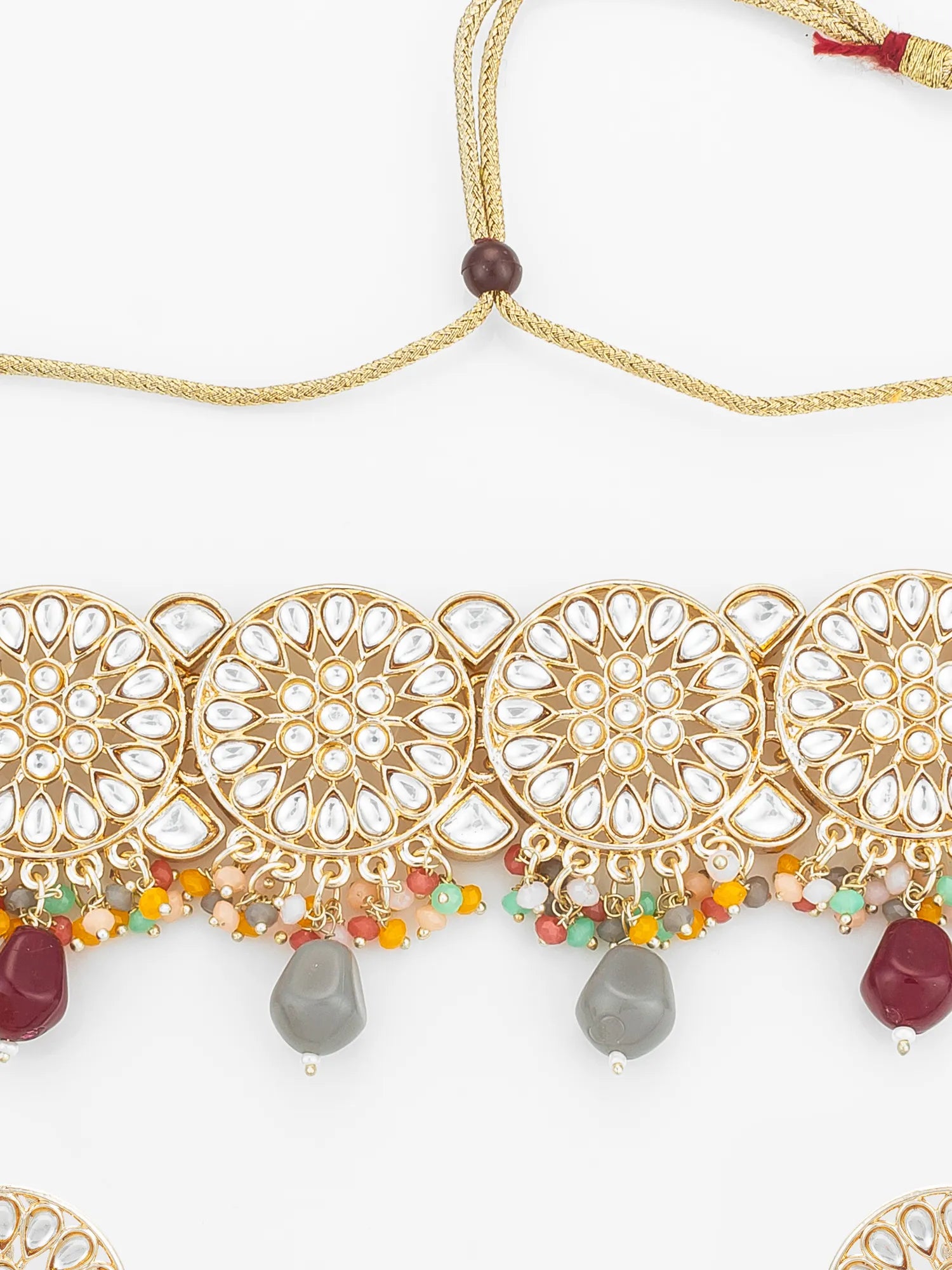 Decorative gold necklace with colorful beads on a white background