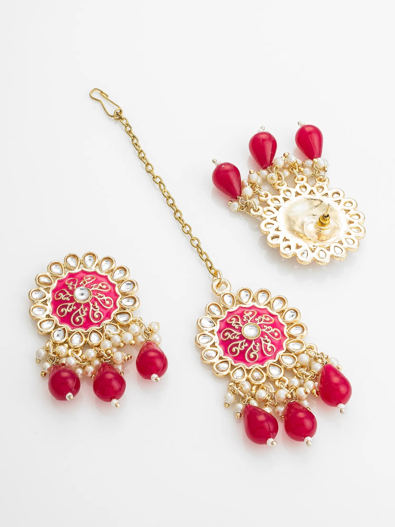 Ornate jewelry set with pink and red elements on a white background