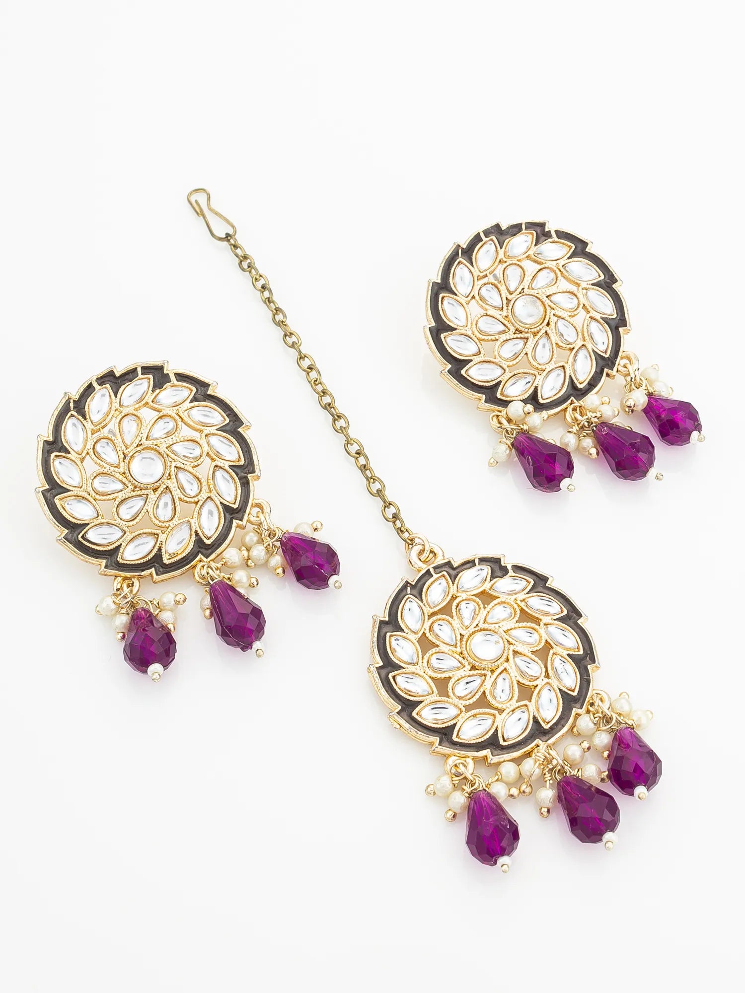 Ornate gold and purple jewelry set on a white background