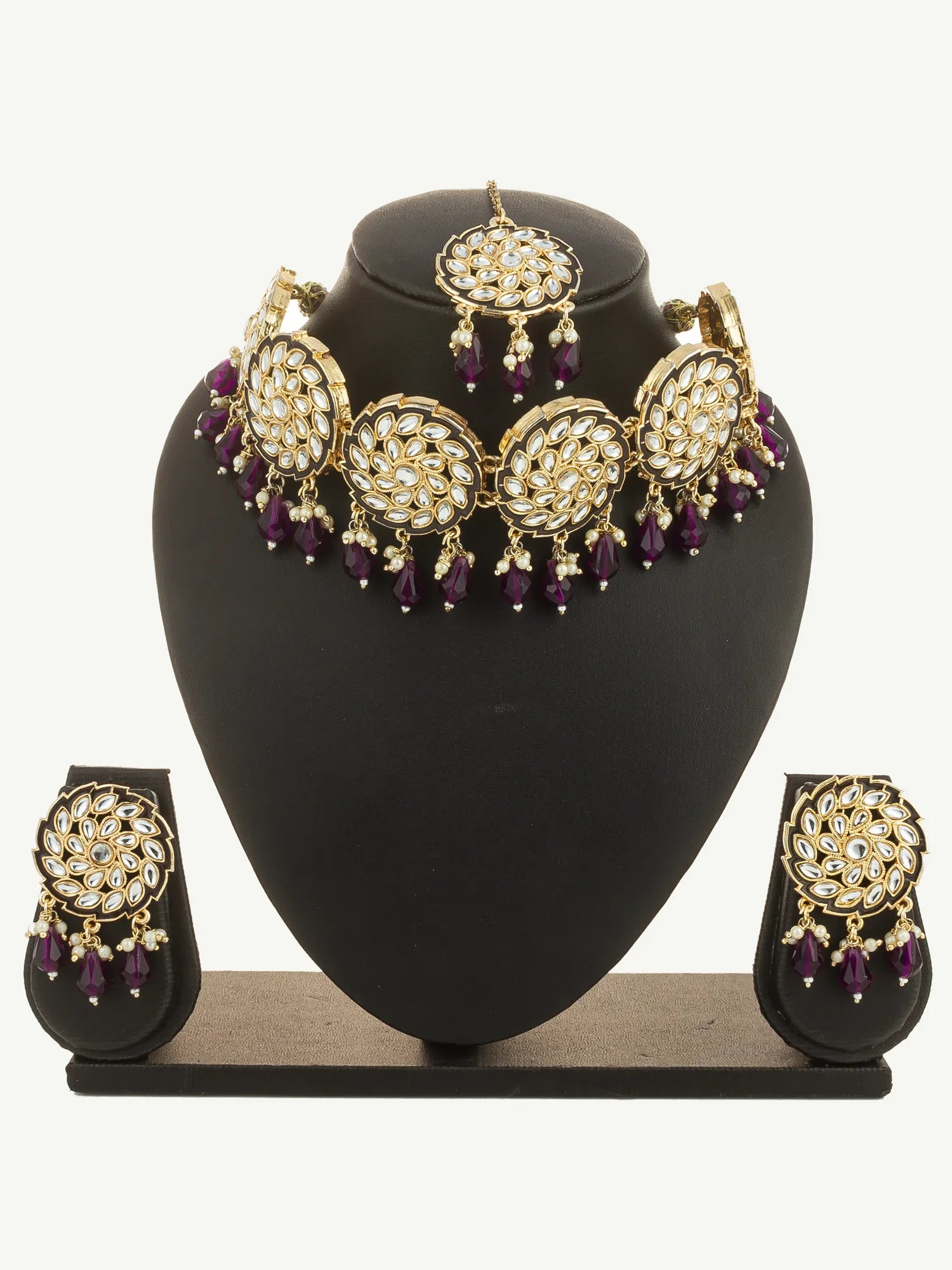 Jewelry set with necklace and earrings on a black stand against a white background