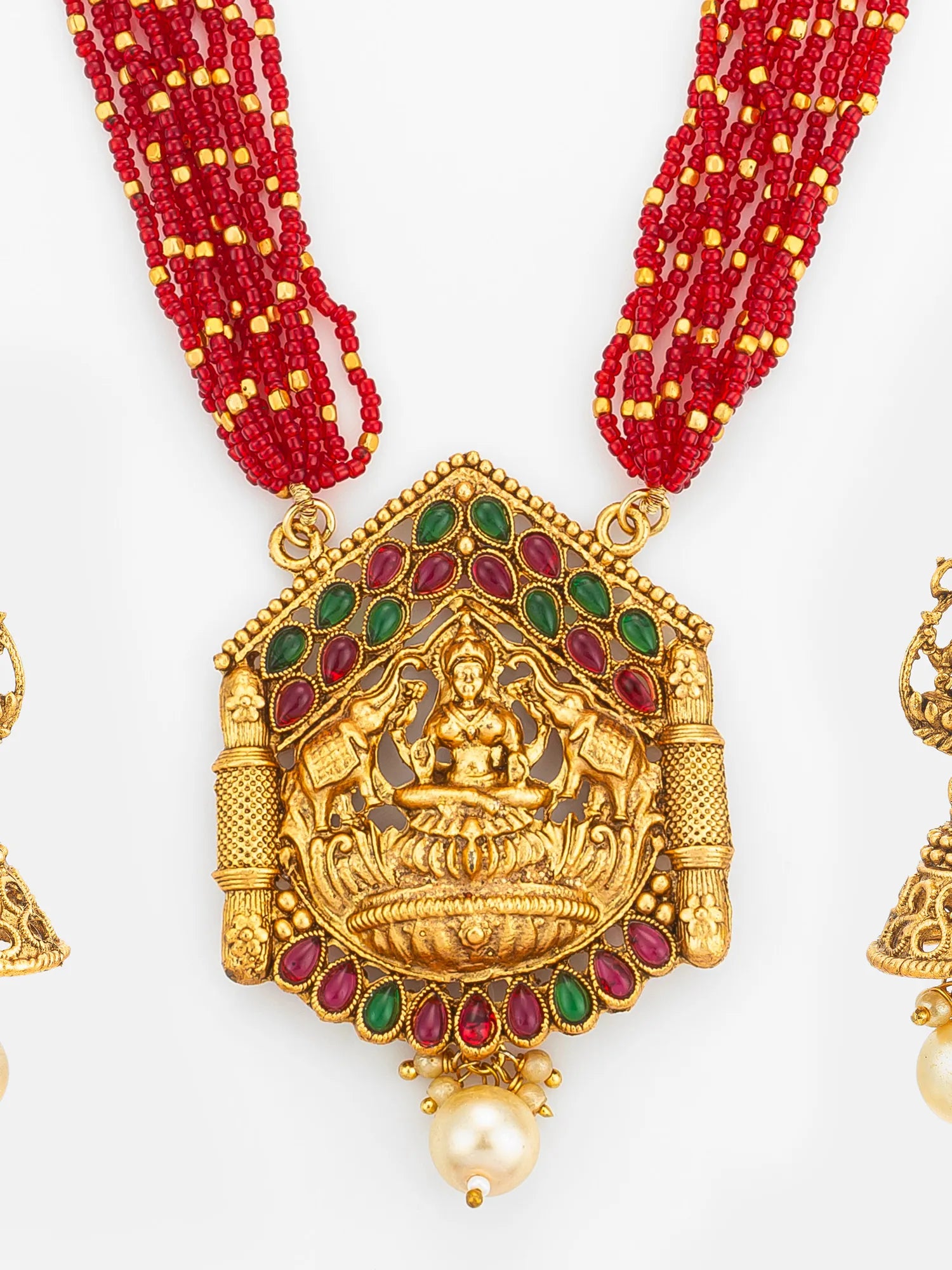 Gold necklace with red beads and a detailed pendant on a white background