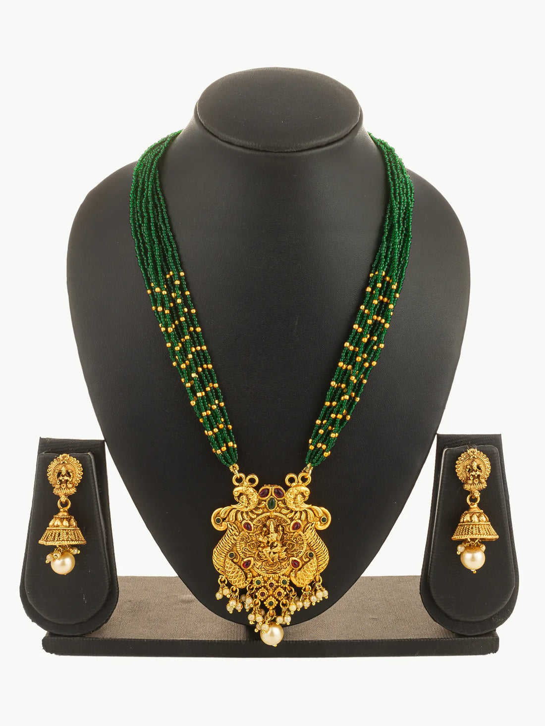 Gold necklace with green beads and matching earrings on a green background