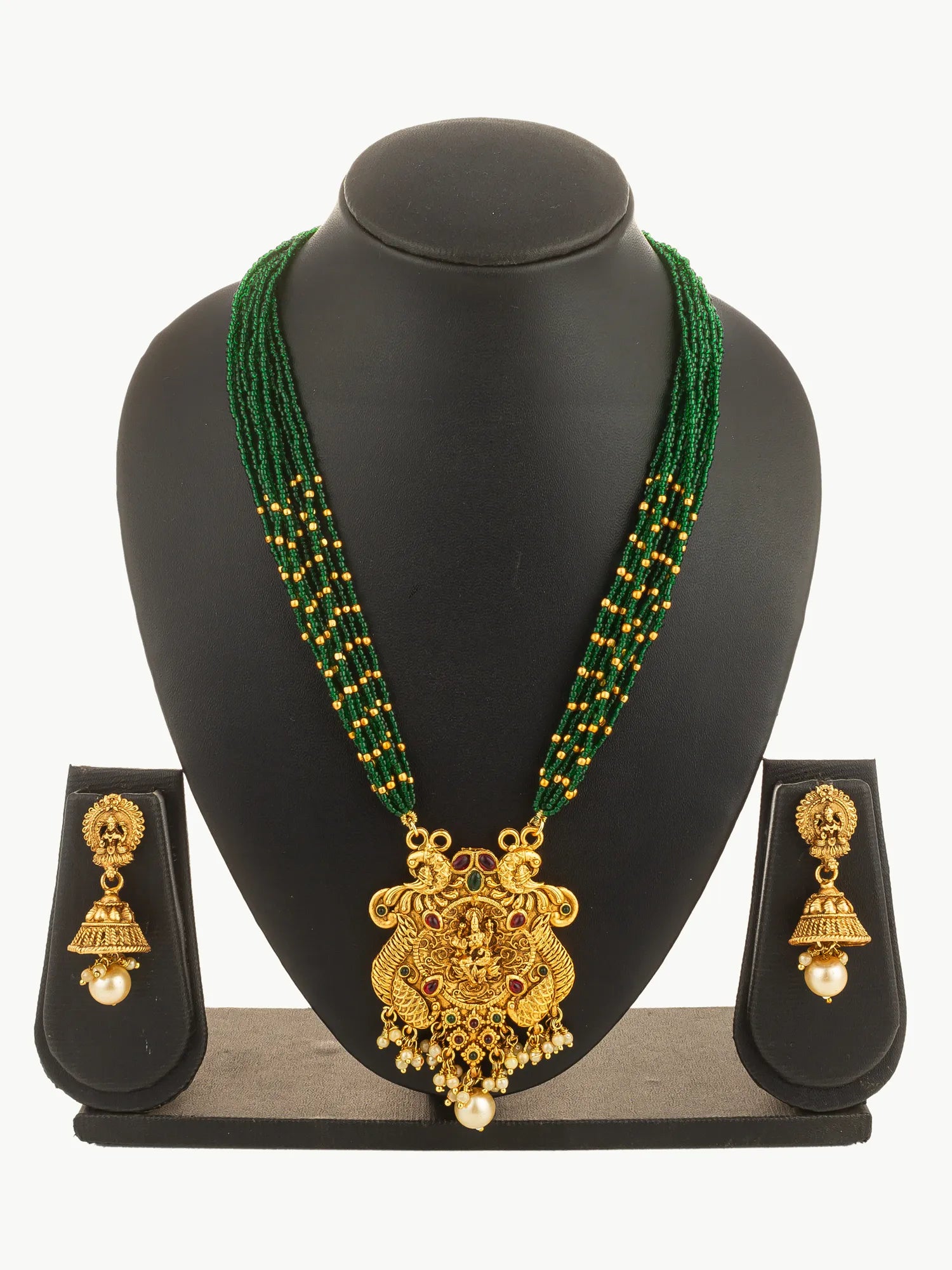 Gold necklace with green beads and matching earrings on a black stand