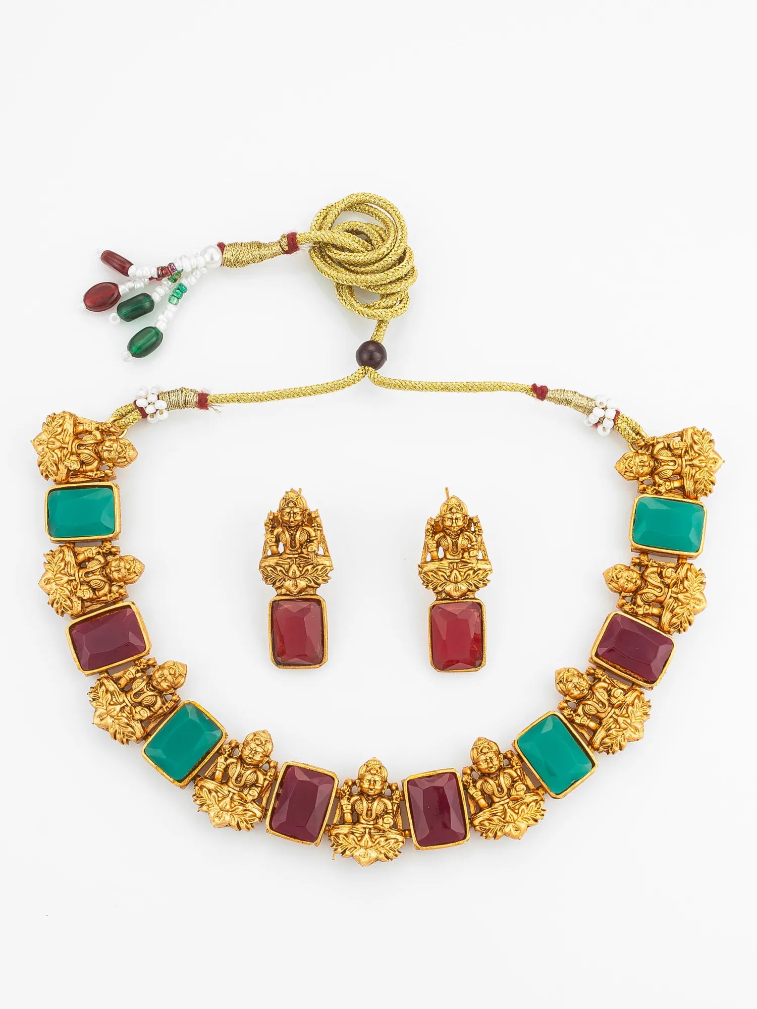 Gold necklace with red and green stones on a white background