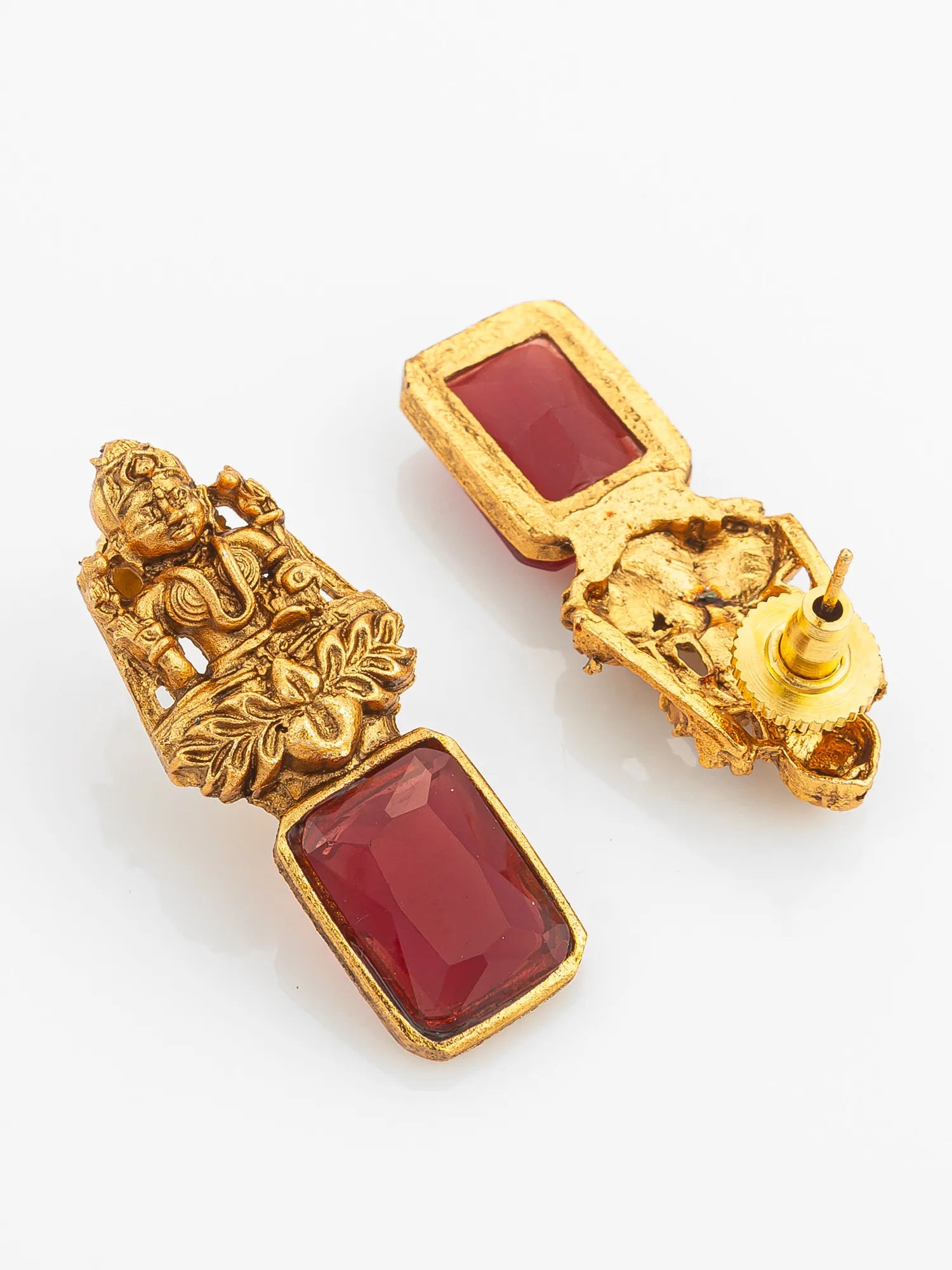 Gold earrings with red stones on a white background