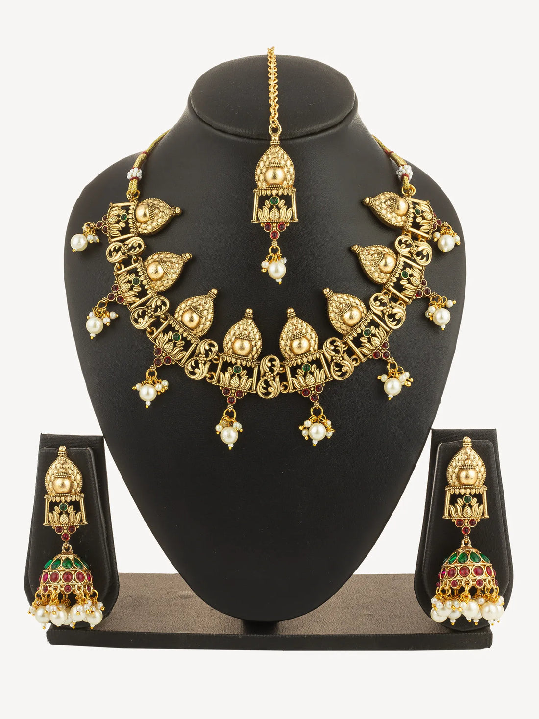 Gold jewelry set with earrings and necklace on a green background