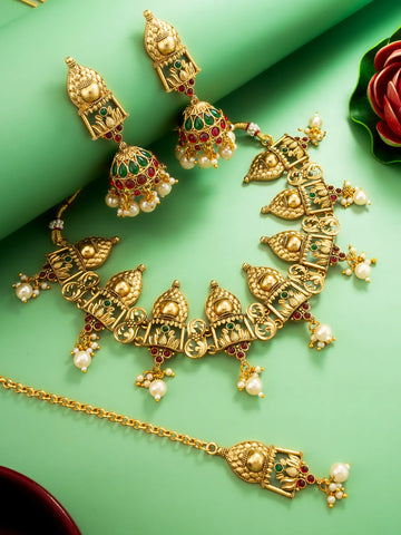 Gold jewelry set with earrings and necklace on a green background