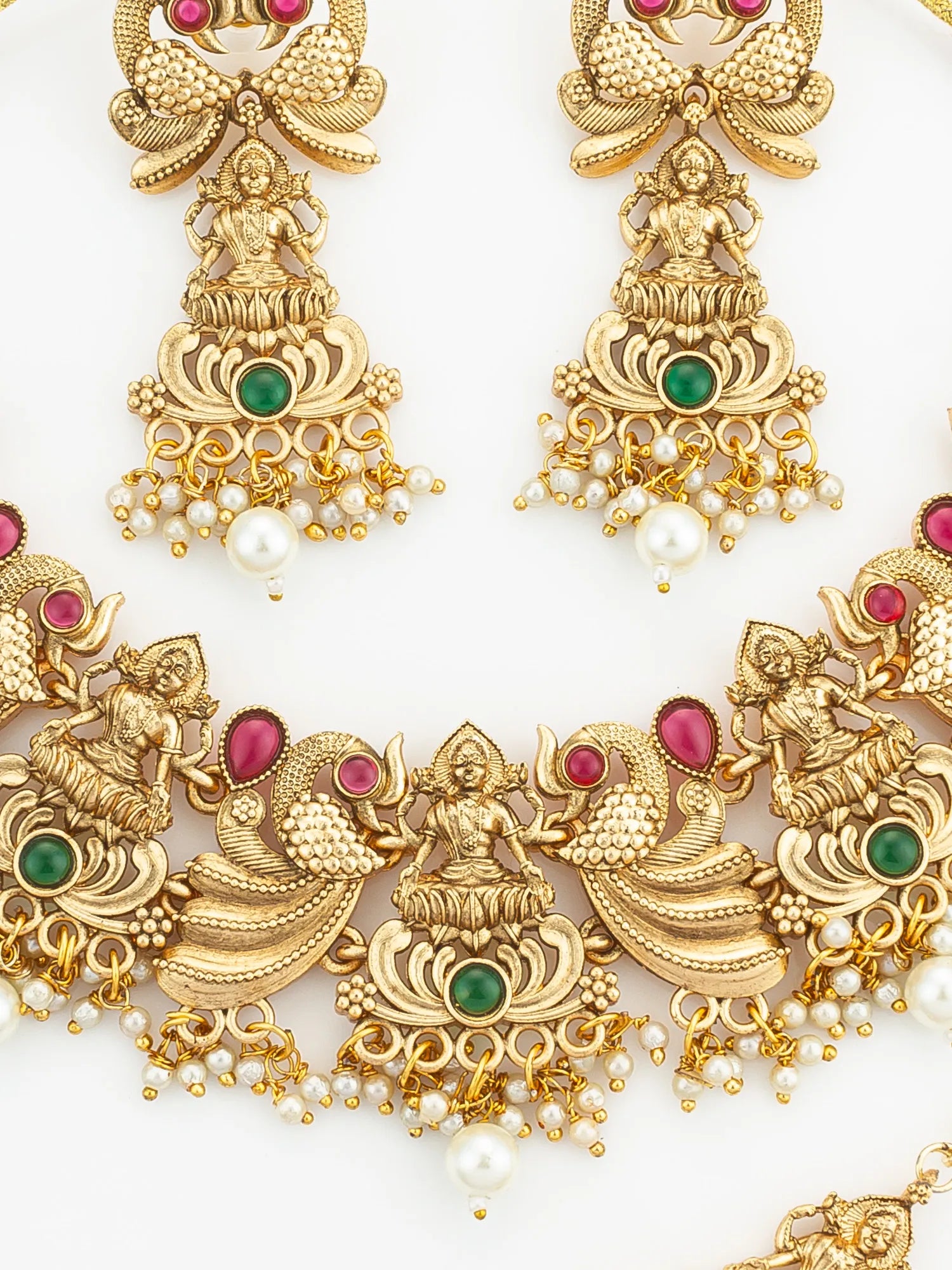 Gold jewelry set with figures, pearls, and gemstones on a white background