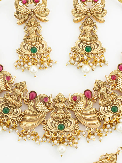 Gold jewelry set with figures, pearls, and gemstones on a white background