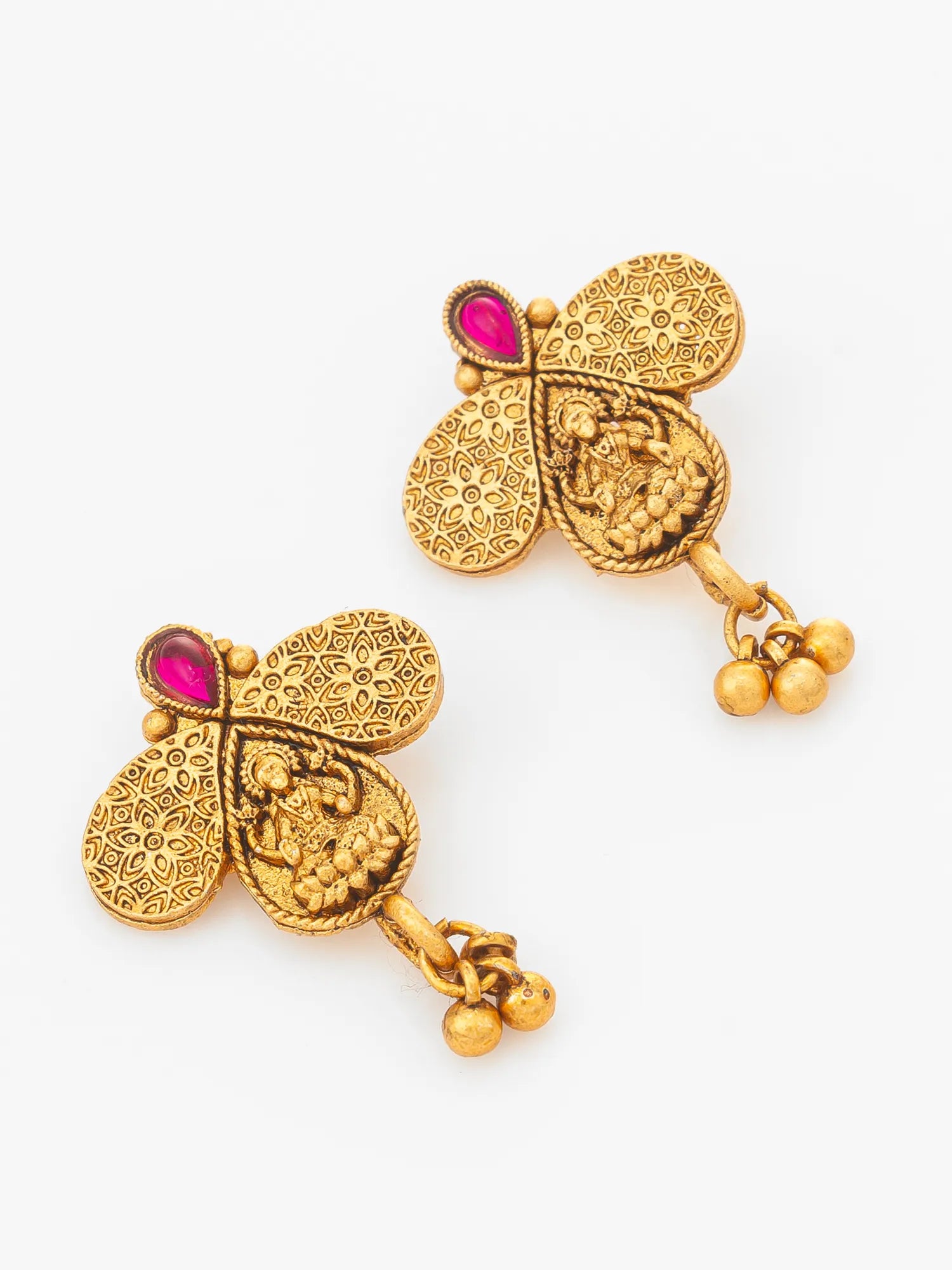 A pair of gold-plated traditional Indian earrings with intricate filigree patterns, small pink gemstone accents, and dangling bead chains, shown on a plain white background.