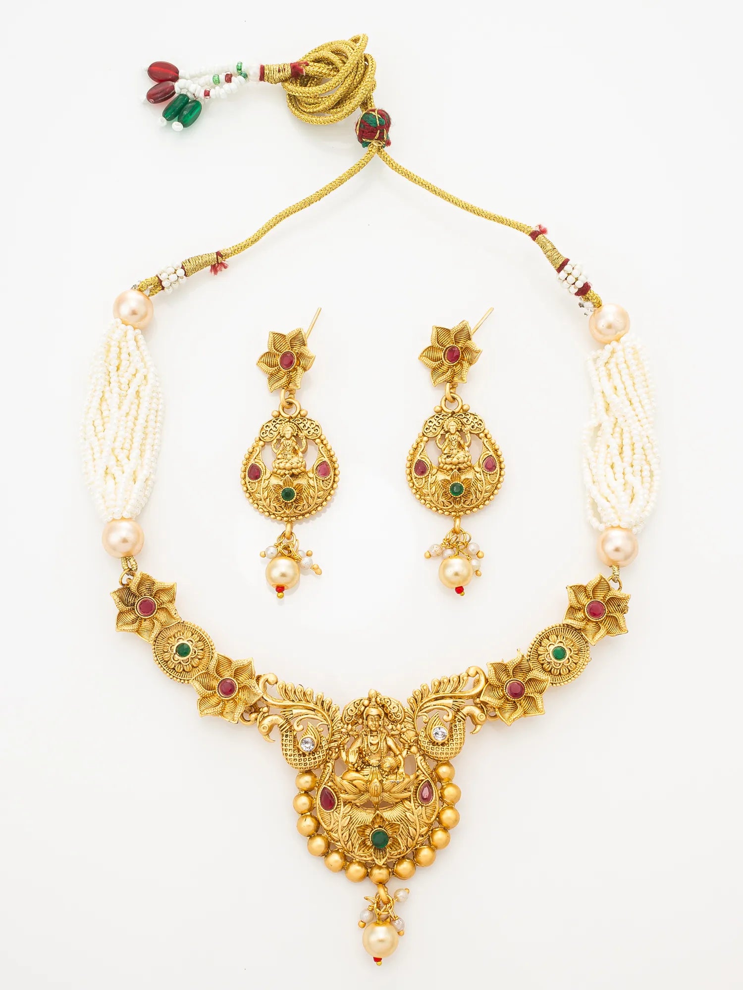 Gold-plated Ganesha jewelry set including a necklace, matching earrings, and a decorative tassel, embellished with white pearls, red and green stones on a white background.