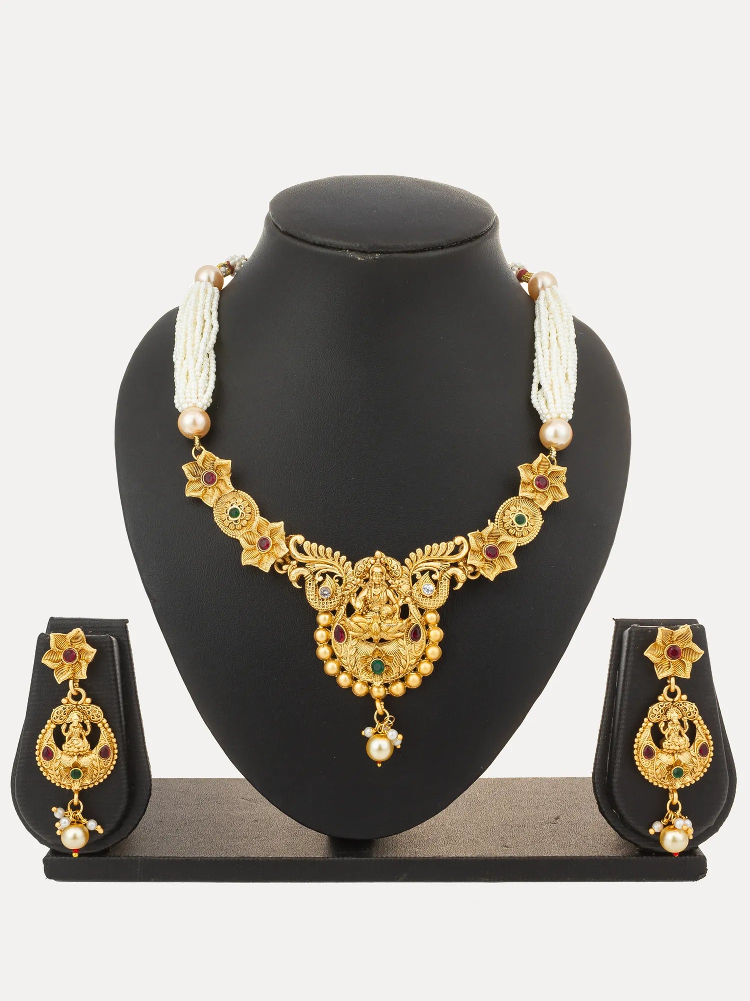 Gold-plated traditional Indian jewelry set featuring a necklace and matching earrings displayed on a black mannequin bust against a light gray background.