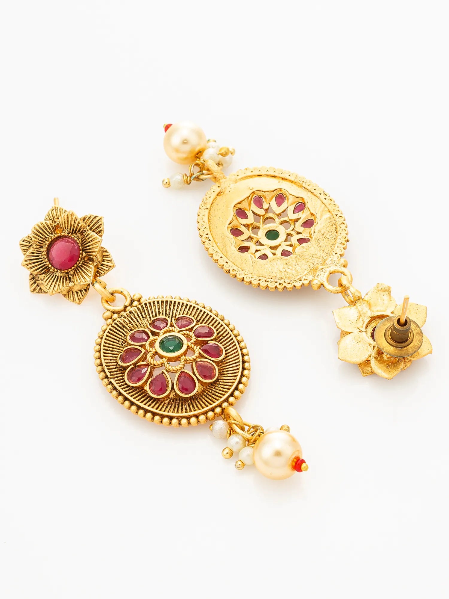 A pair of ornate gold-toned Indian earrings with floral motifs, circular filigree details, and small red and green stone accents, shown on a plain white background.