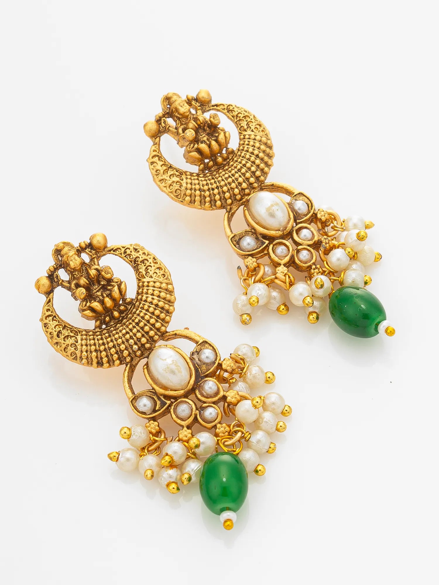 A pair of ornate gold-toned traditional earrings with white pearl-like beads, small gold beads, and green teardrop-shaped stones, displayed on a clean white background.