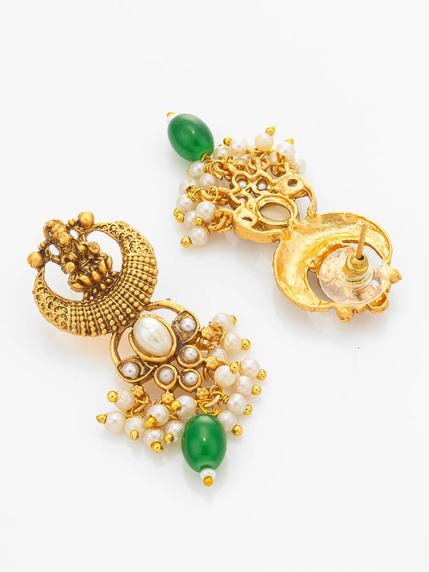 A pair of ornate gold-toned traditional Indian jhumka earrings decorated with white faux pearls, green cabochon beads, and gold filigree, displayed on a clean white background.