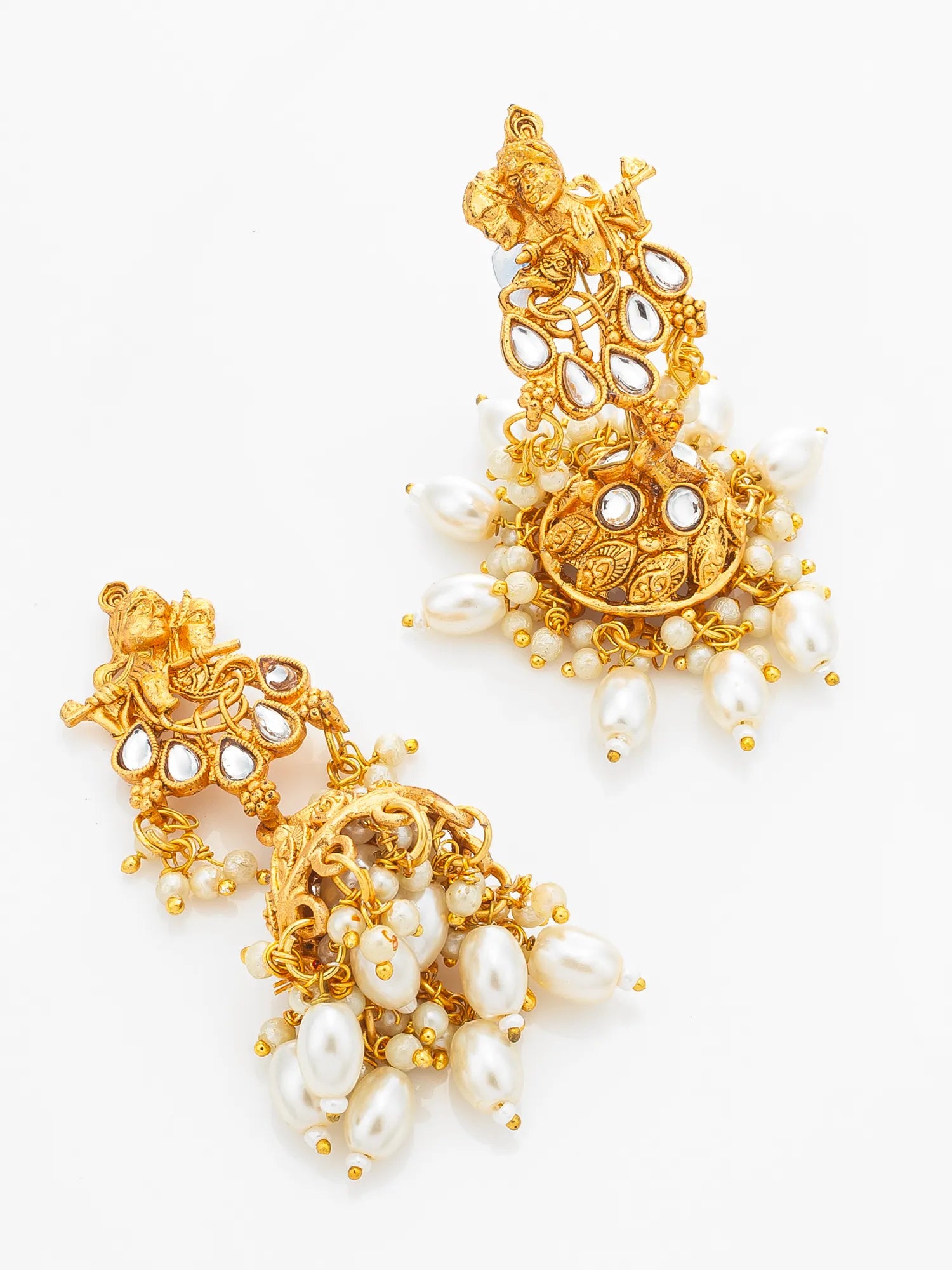 A pair of ornate gold-toned Jhumka earrings decorated with white faux pearls, clear stones, and intricate filigree details, displayed on a clean white background.