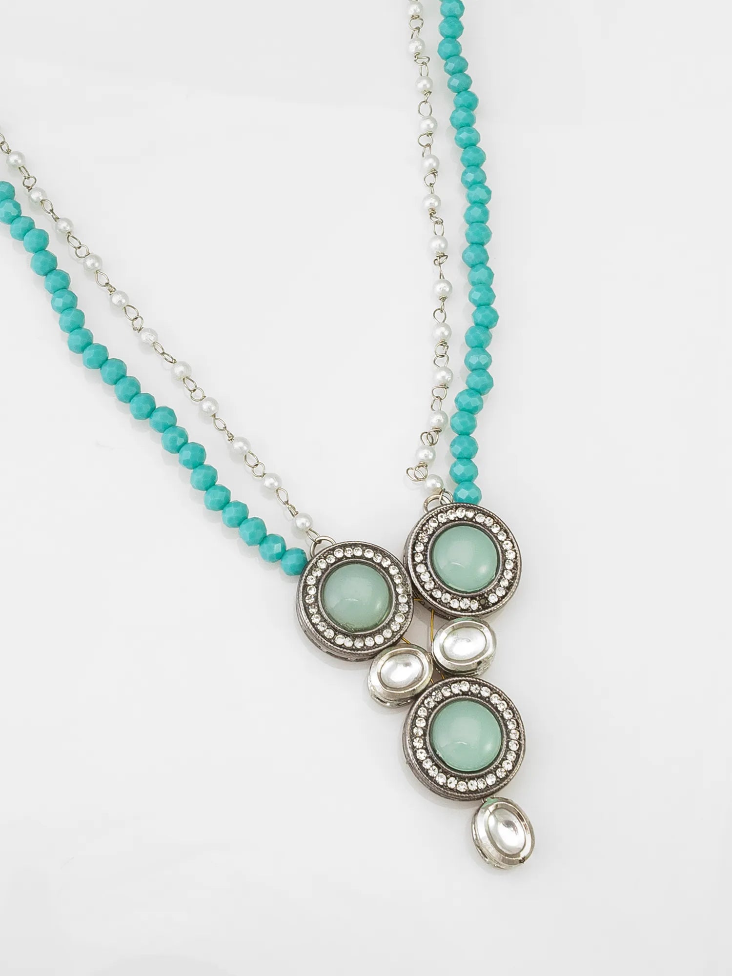 Necklace with turquoise beads and circular pendant on a white background