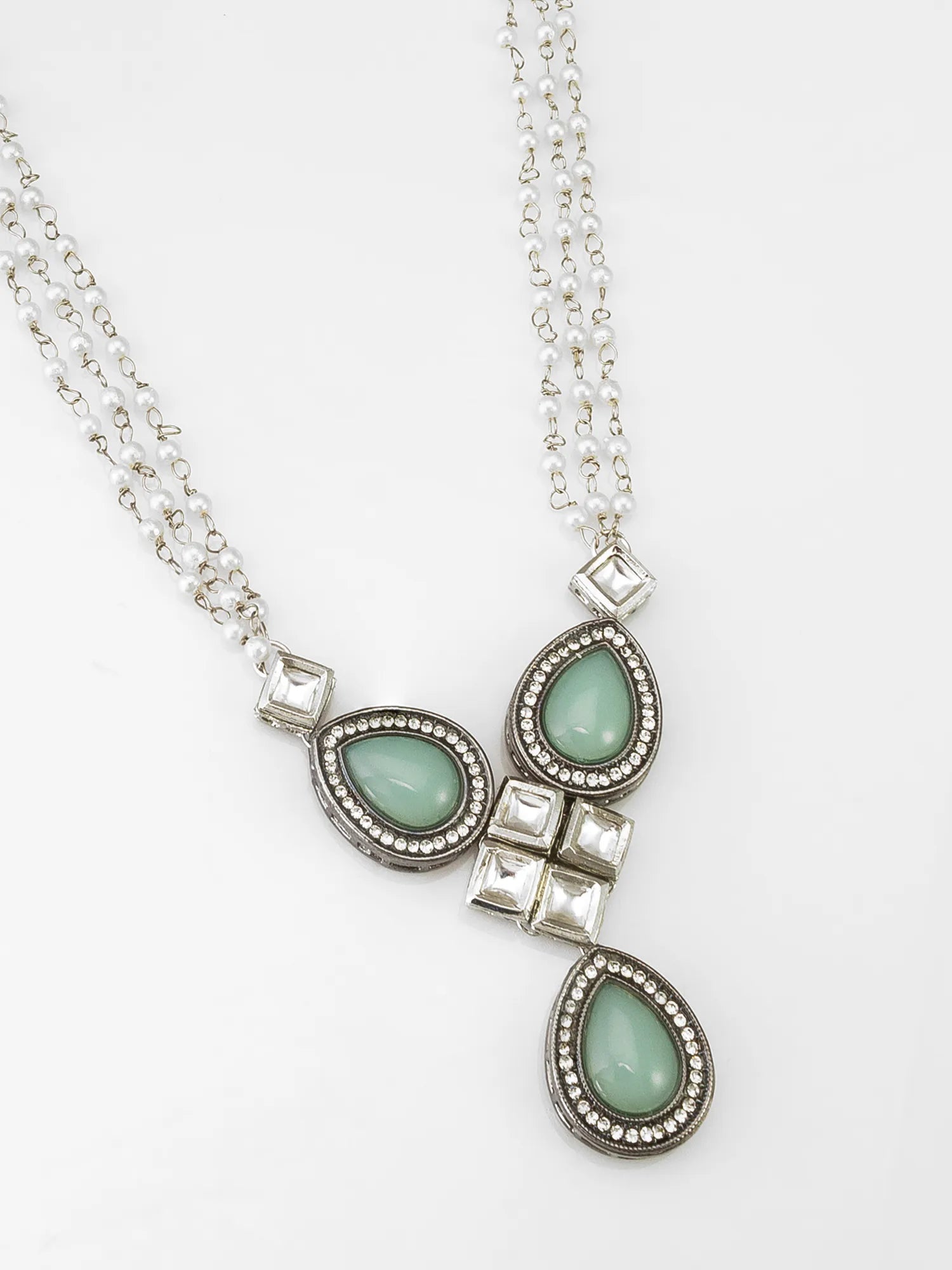 A silver double-strand necklace featuring three teardrop-shaped light green gemstone pendants, each surrounded by small clear rhinestones and accented with square silver beads, displayed on a clean white background.