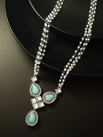 Necklace with turquoise stones and silver accents on a black background
