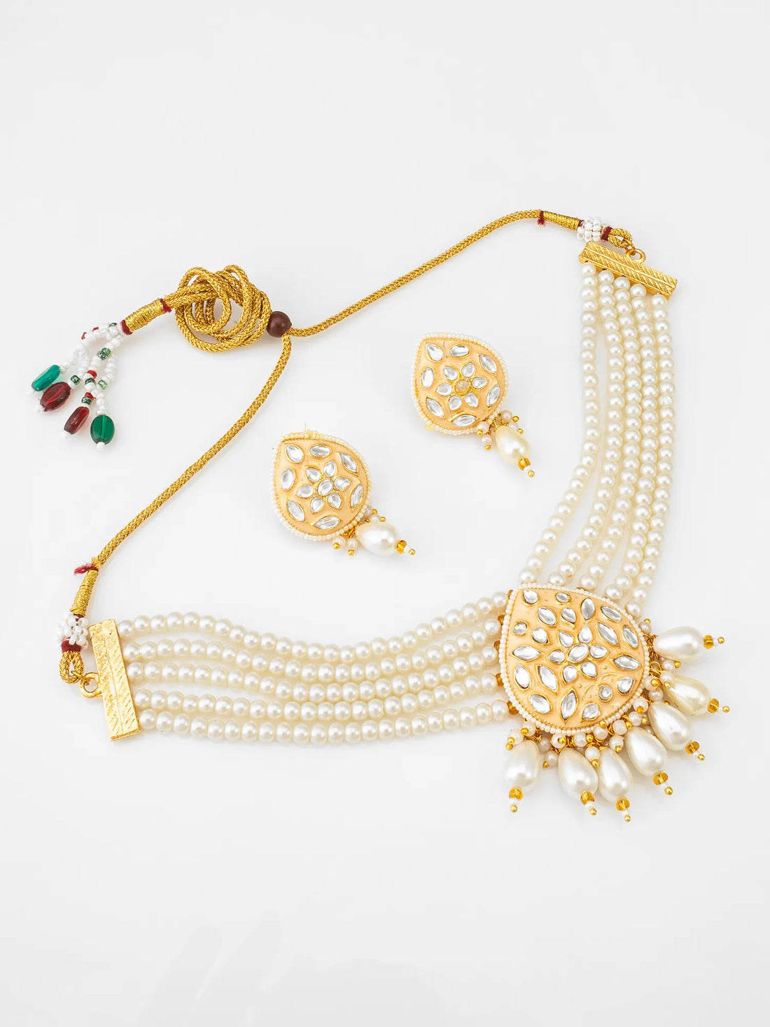 Gold-plated multi-strand pearl necklace and matching earrings with intricate stone embellishments, displayed on a textured red background.