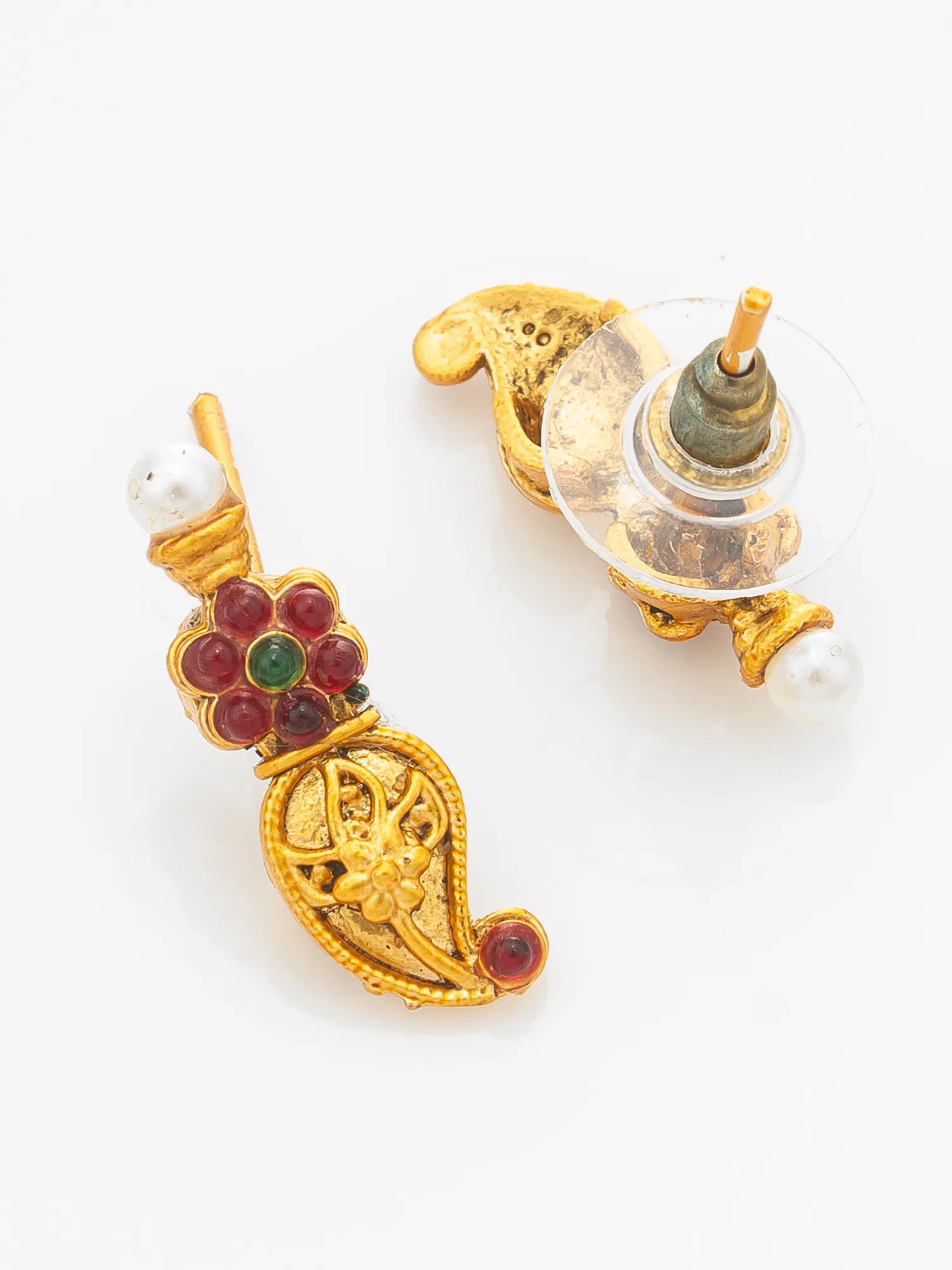 A pair of gold-toned traditional Indian earrings with red and green stone accents and white pearl beads, displayed on a clean white background.