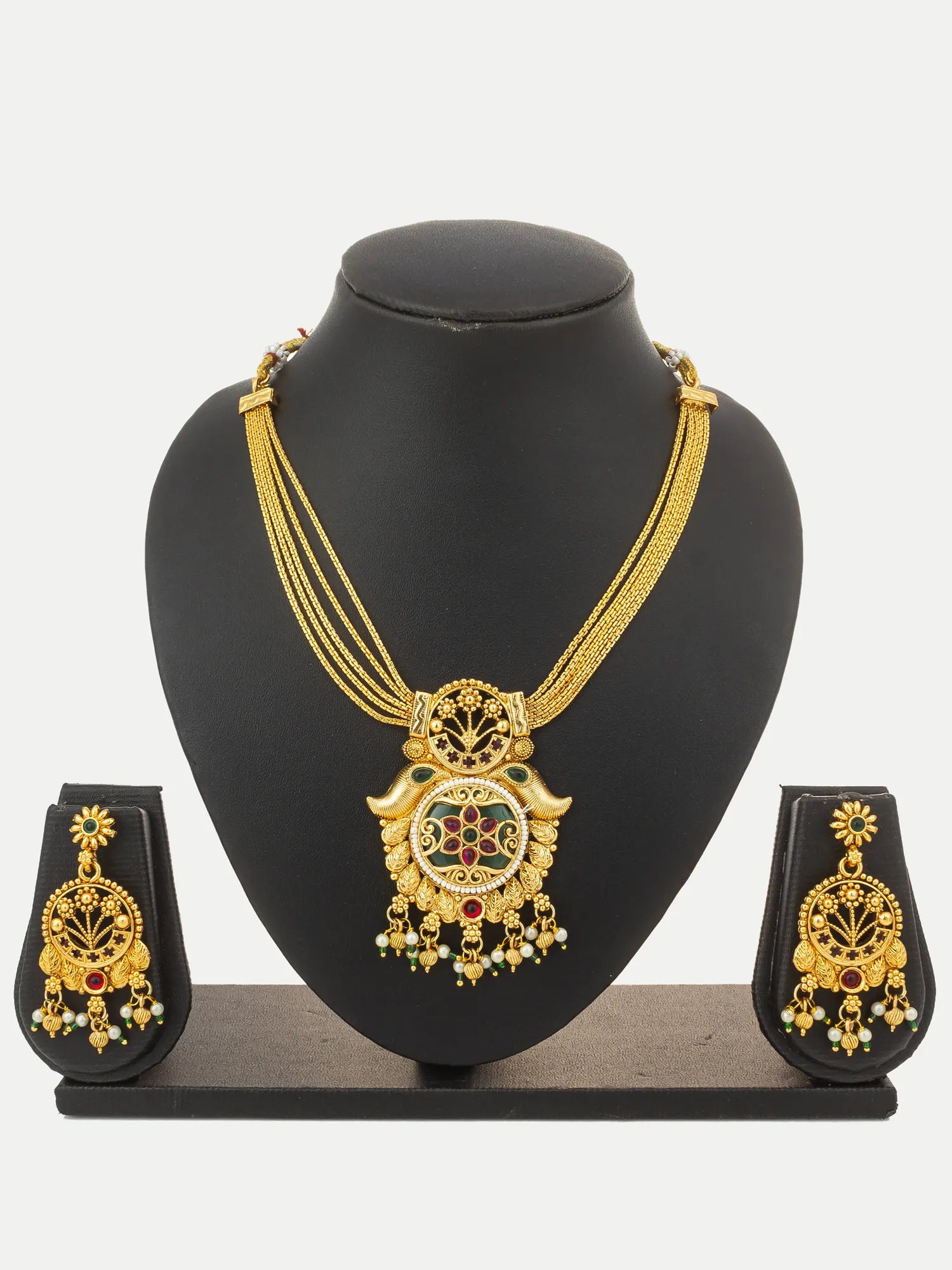 Gold-toned traditional jewelry set displayed on a black mannequin bust, including a layered necklace with a decorative pendant, matching earrings, and a small matching box on a light gray background.