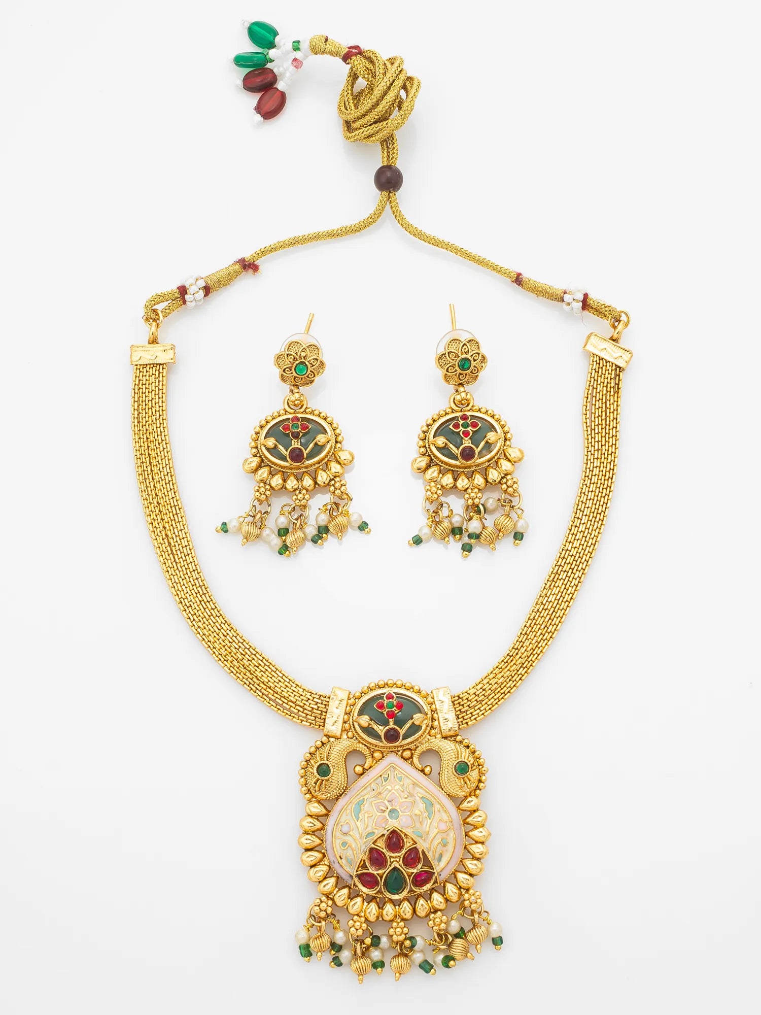 Gold-plated traditional Indian jewelry set featuring a necklace with a large ornate pendant and matching drop earrings, decorated with green and red enamel details and white stones, displayed on a clean white background.