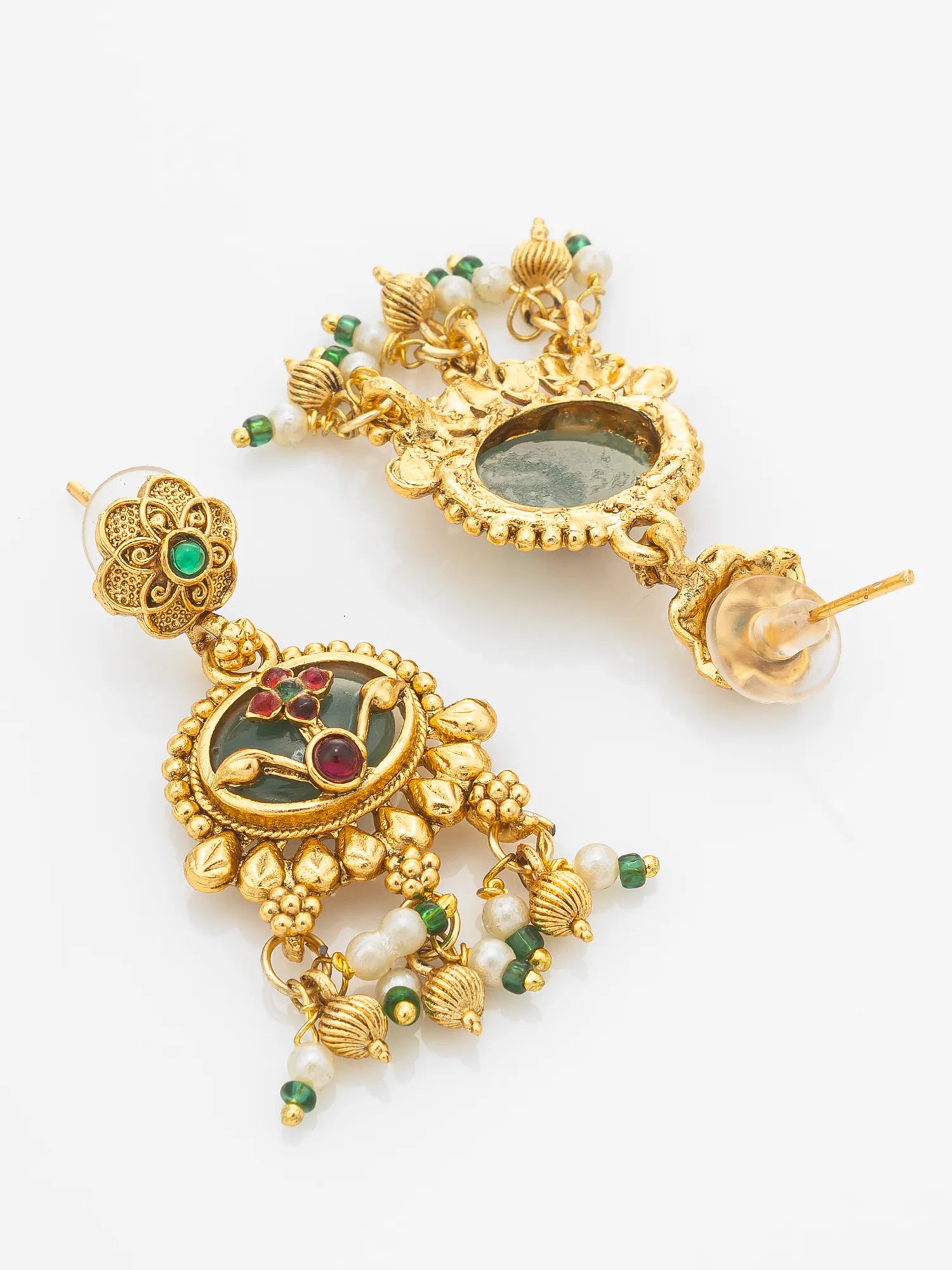 A pair of ornate gold-toned traditional Indian jhumka earrings decorated with green and red stones and white pearl-like beads, displayed on a clean white background.