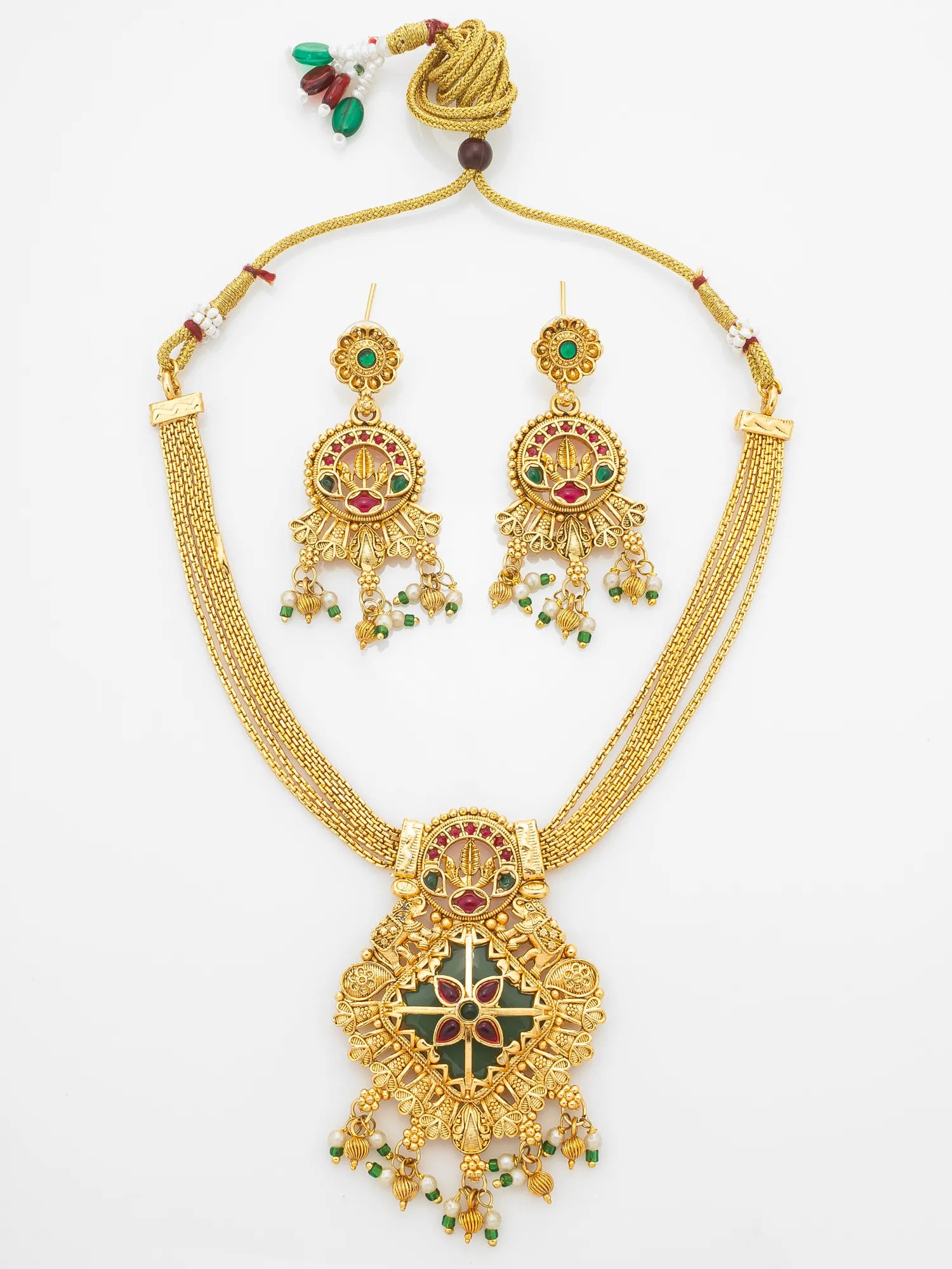 Gold-tone traditional Indian jewelry set featuring a necklace and matching earrings with green and red enamel details and small bead accents, displayed on a clean white background.