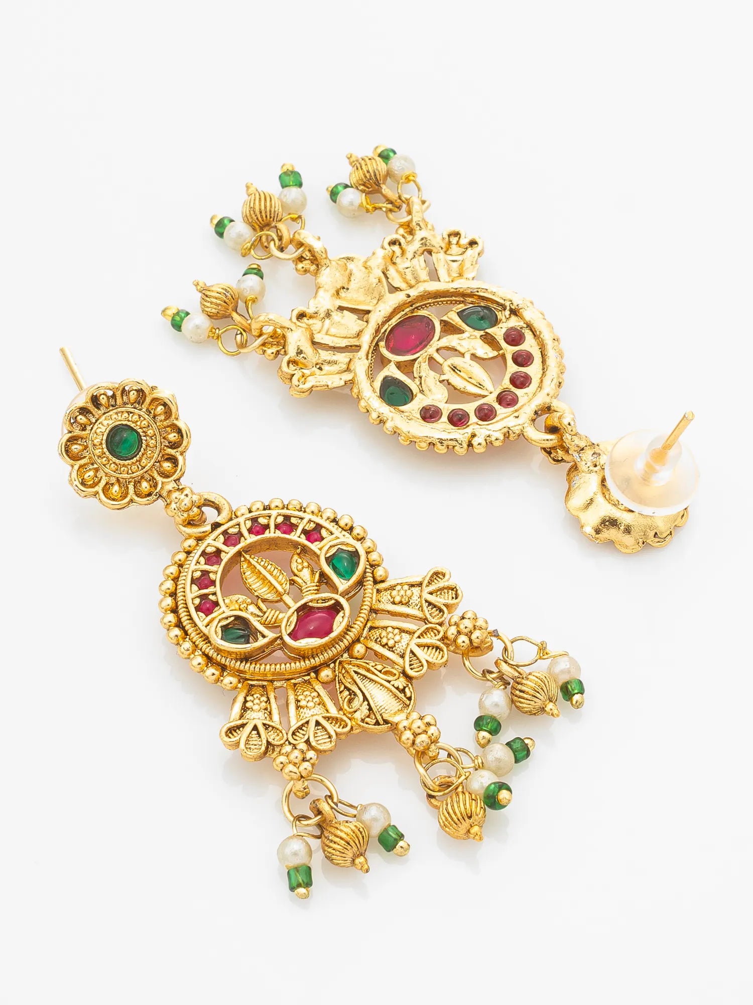 A pair of ornate gold-toned traditional Indian jhumka earrings decorated with green and red enamel, white pearl-like beads, and small dangling elements, shown on a plain white background.