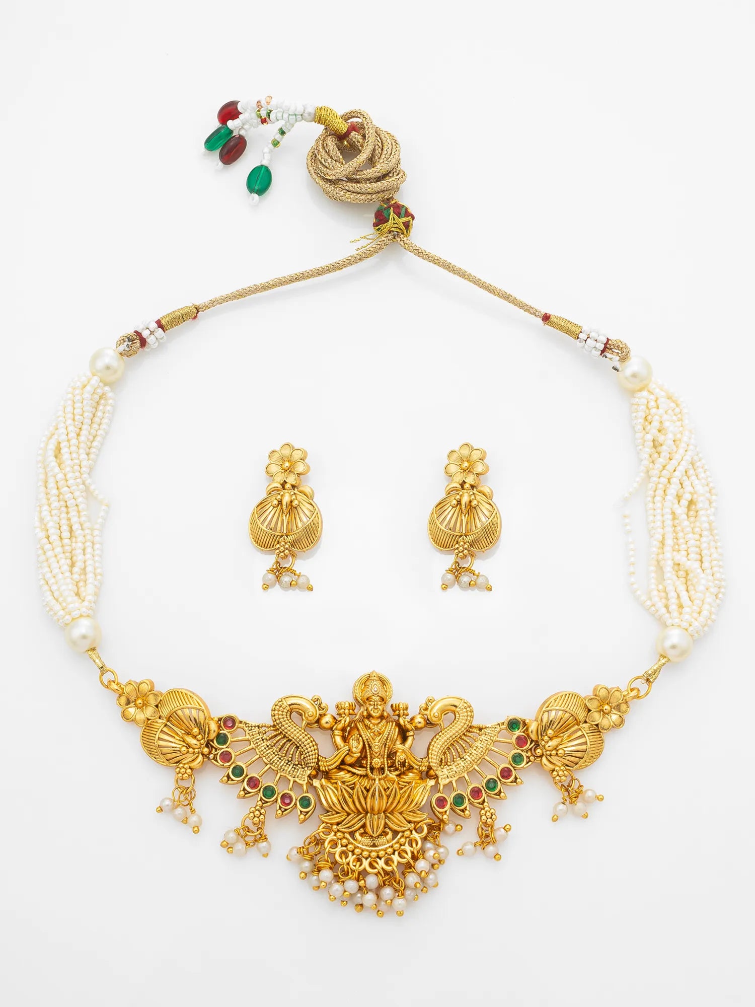 Gold and white pearl traditional Indian jewelry set featuring a necklace with a detailed central pendant, matching earrings, and a decorative cord with small red and green bead accents, displayed on a white background.