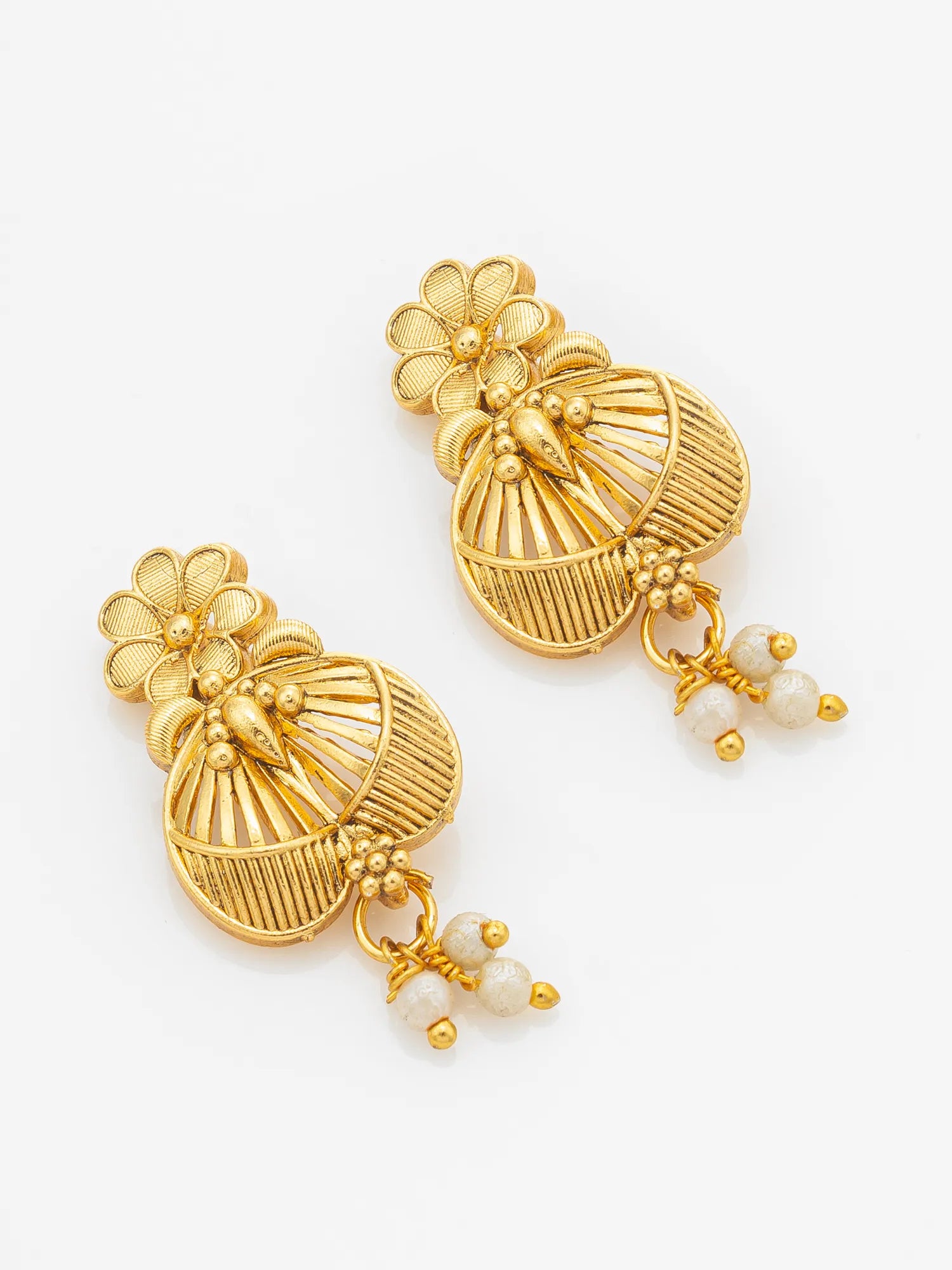 A pair of gold-toned traditional Indian jhumka earrings with floral tops, ribbed circular dangles, and small white bead drops, shown on a clean white background.
